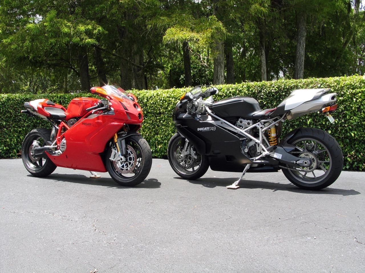 Two Ducati motorcycles parked on asphalt HD Wallpaper
