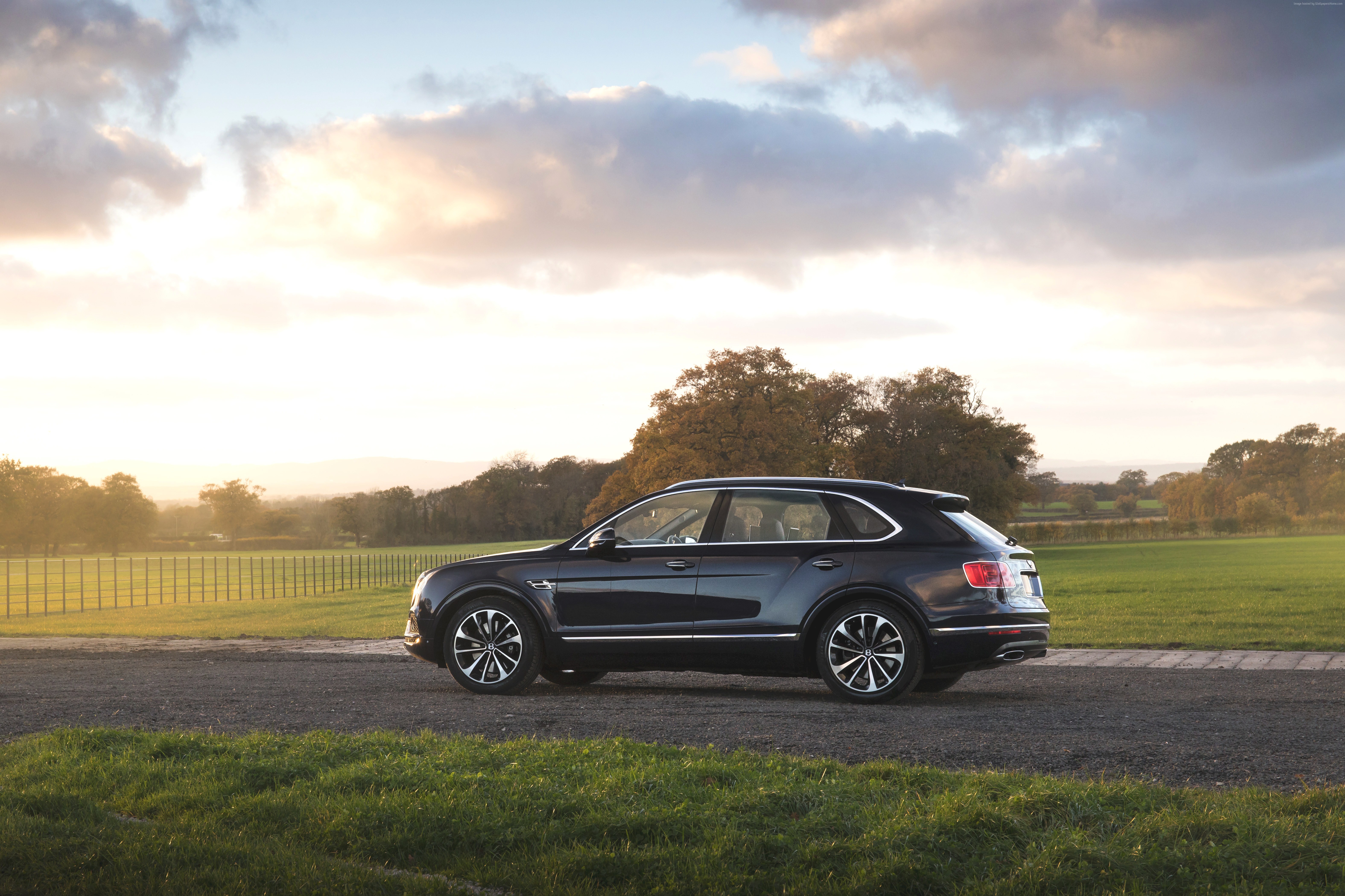 Bentley Bentayga SUV on a rural road at sunset HD Wallpaper