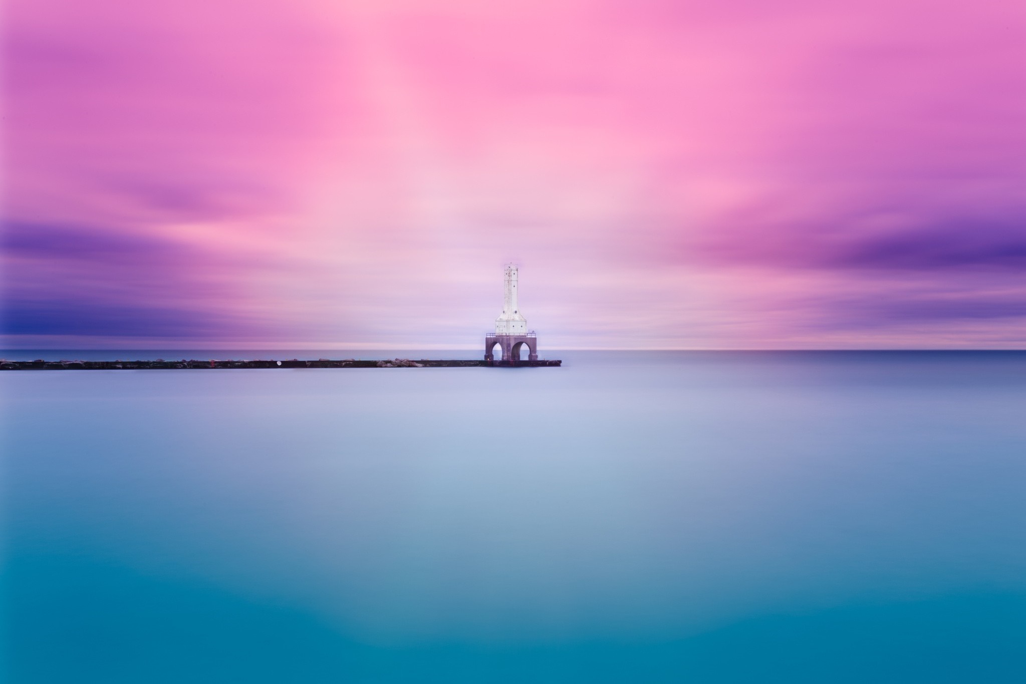 Lighthouse on a pier at sunset with colorful sky HD Wallpaper