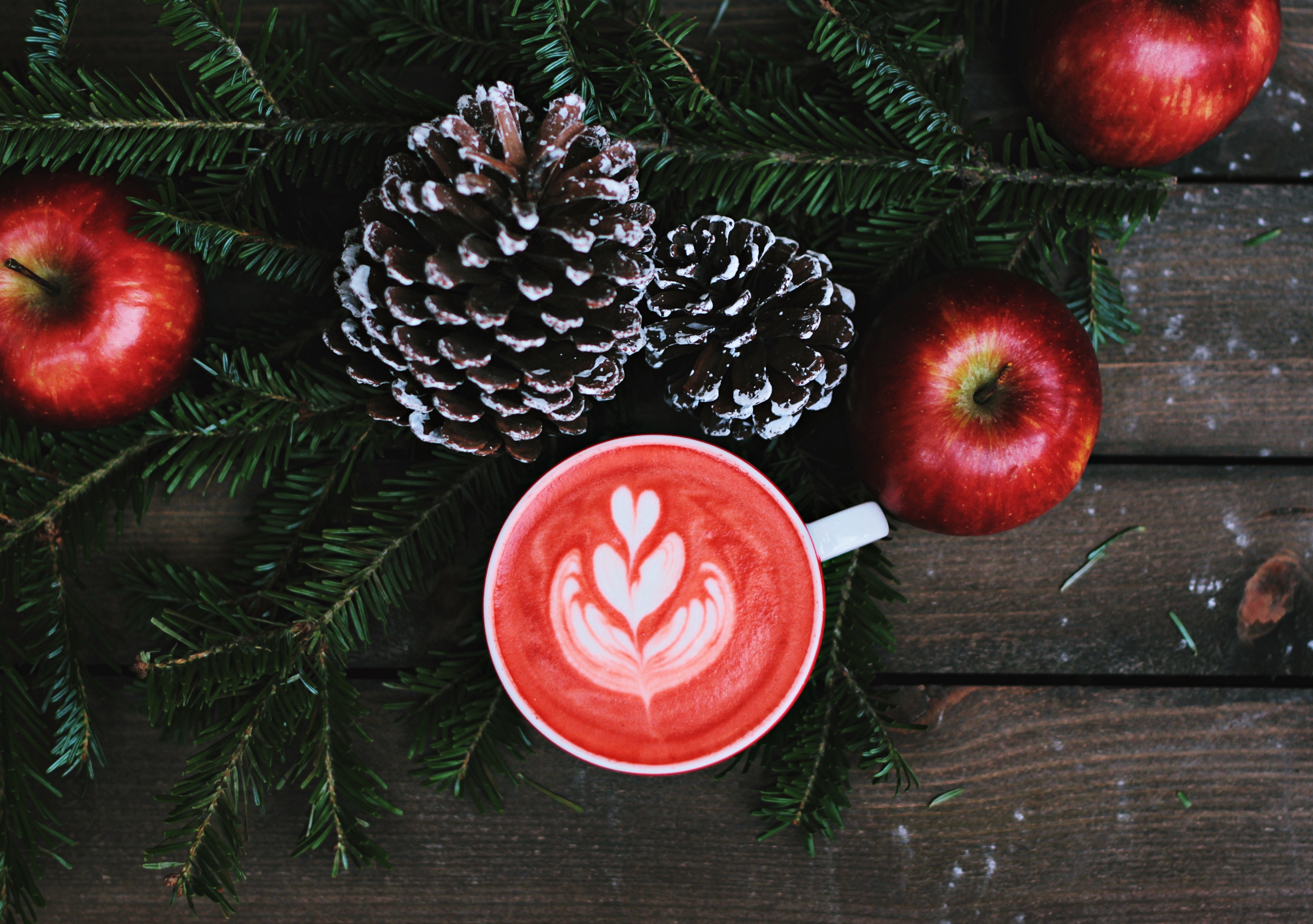Red latte with apples and pine cones on wood HD Wallpaper