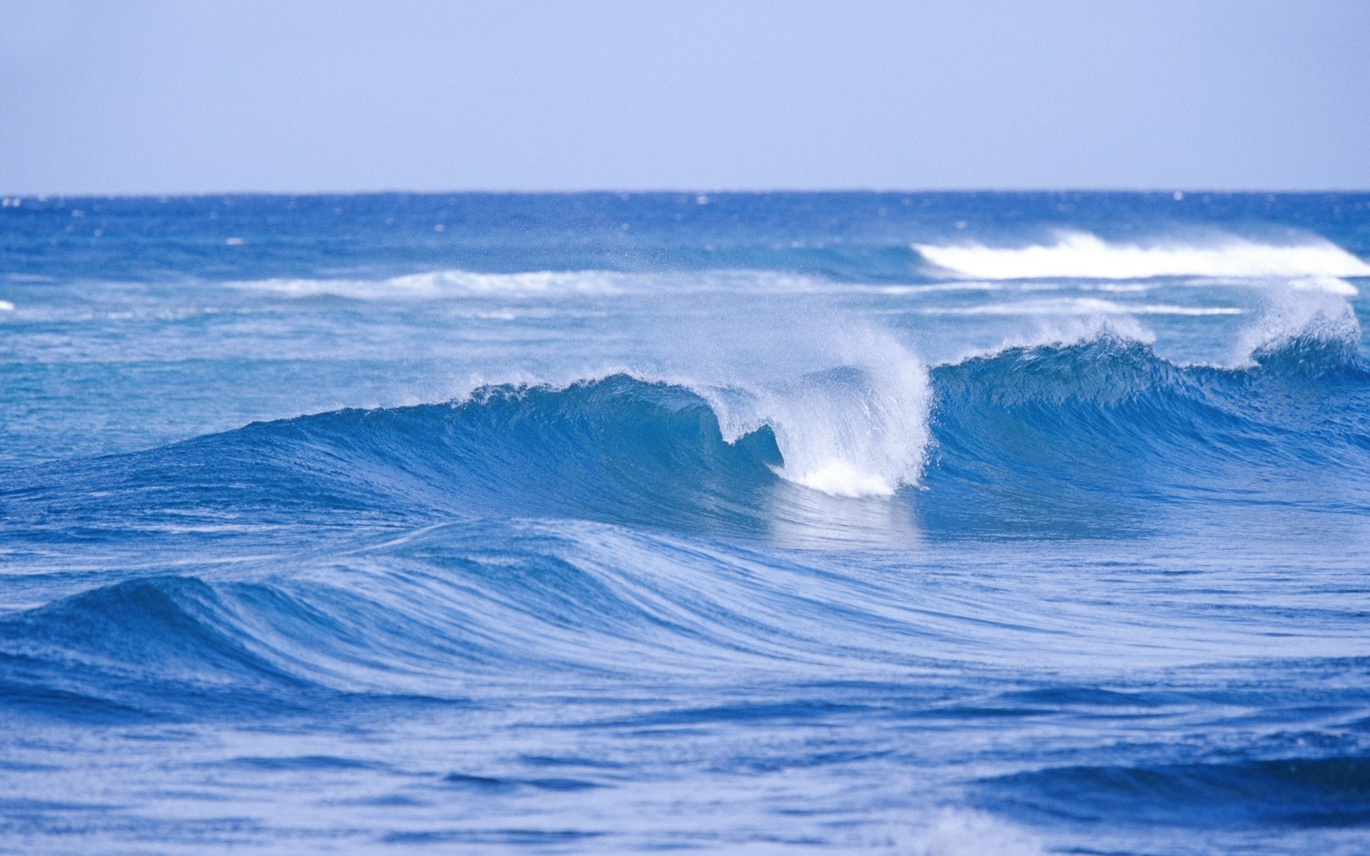 Ocean waves crashing under a clear sky HD Wallpaper