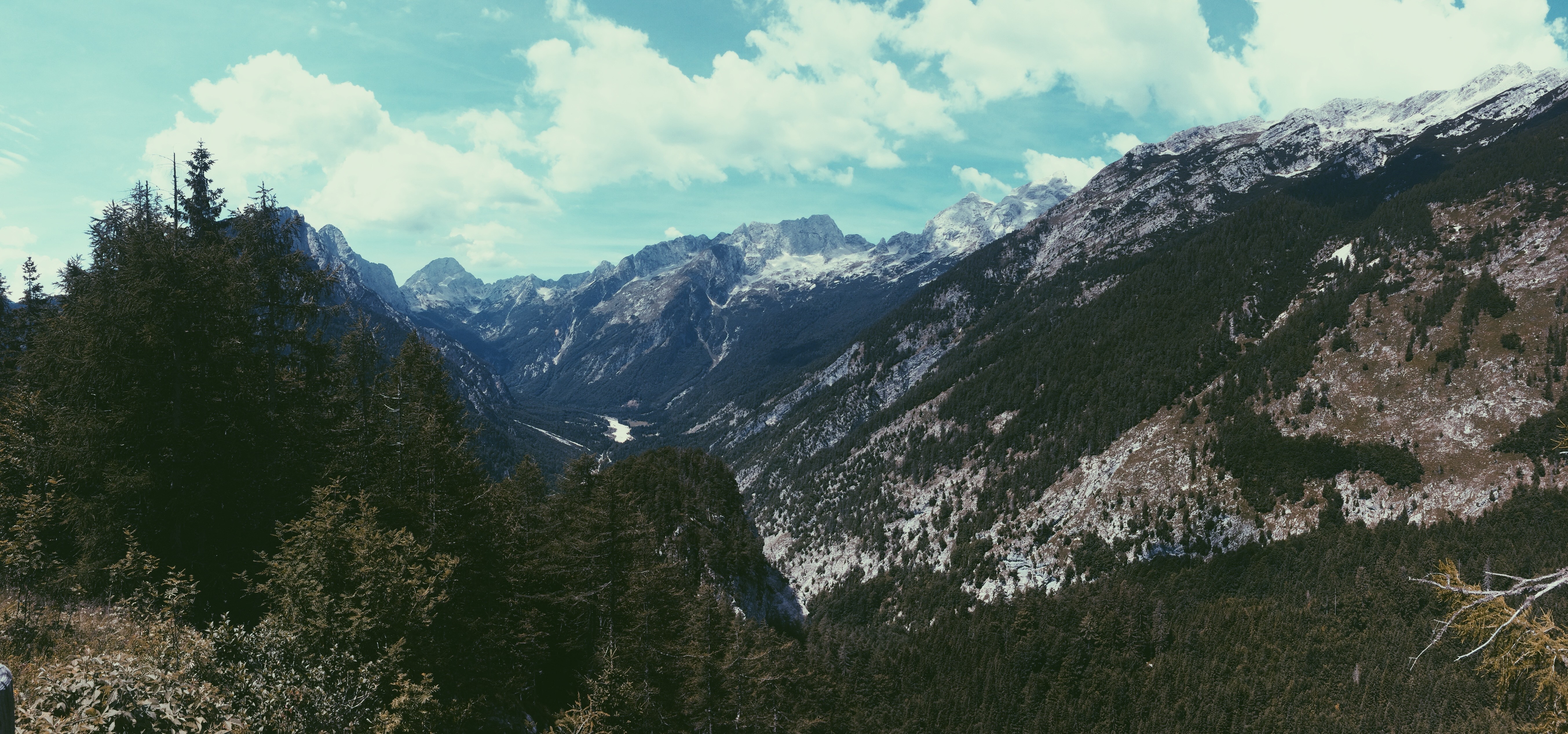 Panoramic view of a mountain valley with snow-capped peaks HD Wallpaper