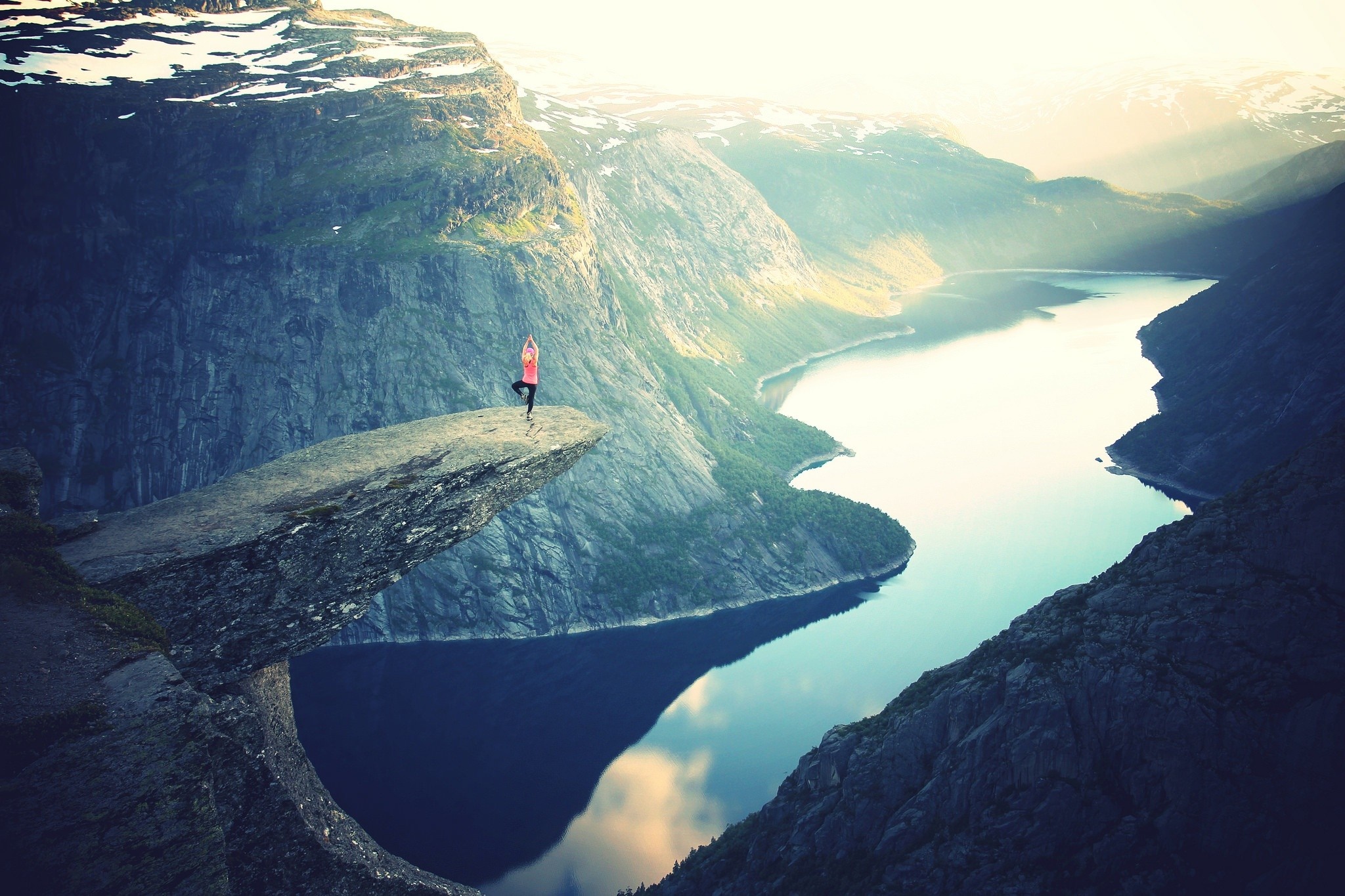 Woman doing yoga on Trolltunga cliff overlooking fjord HD Wallpaper