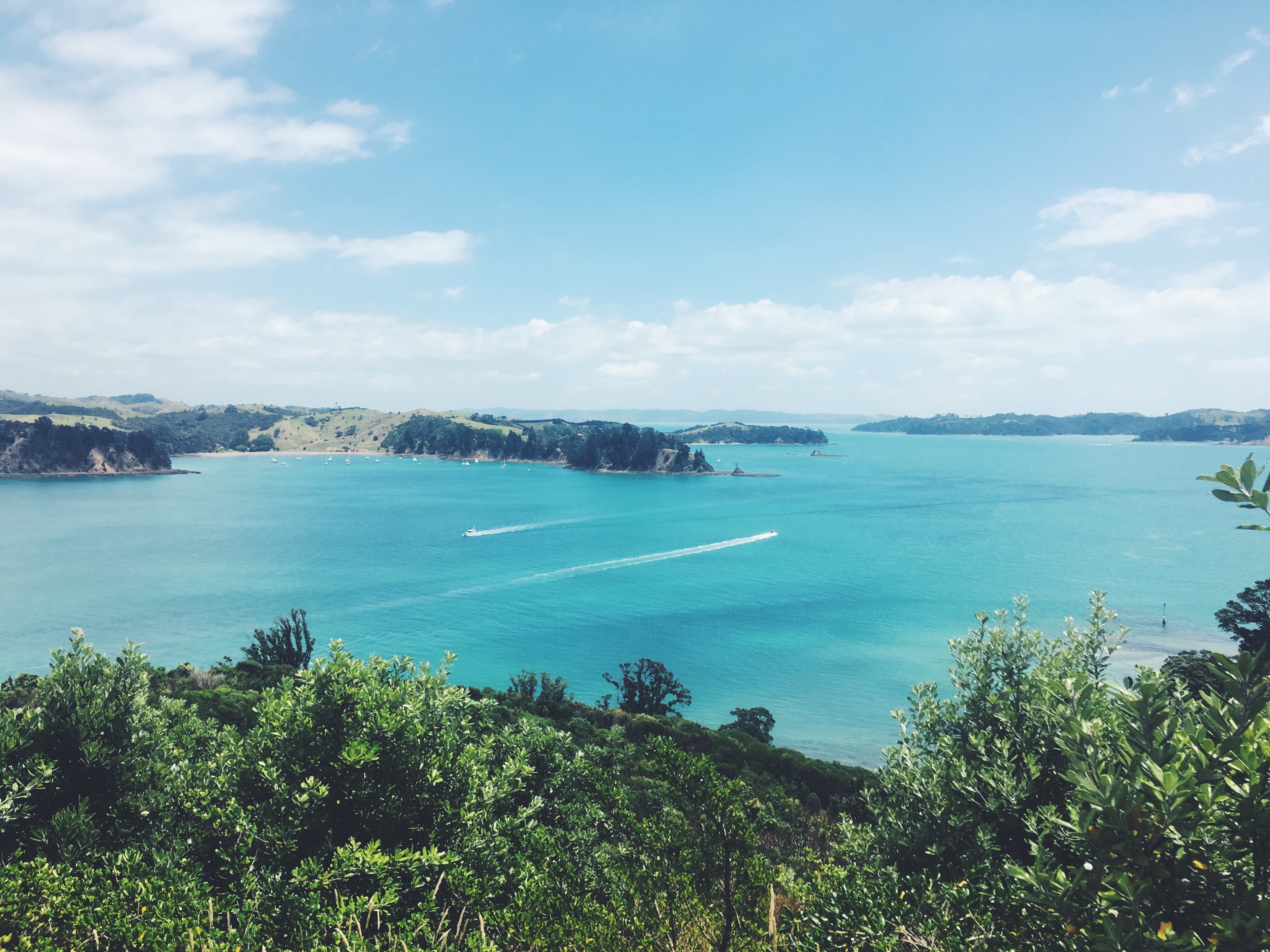 Boats on a turquoise bay with green hills HD Wallpaper