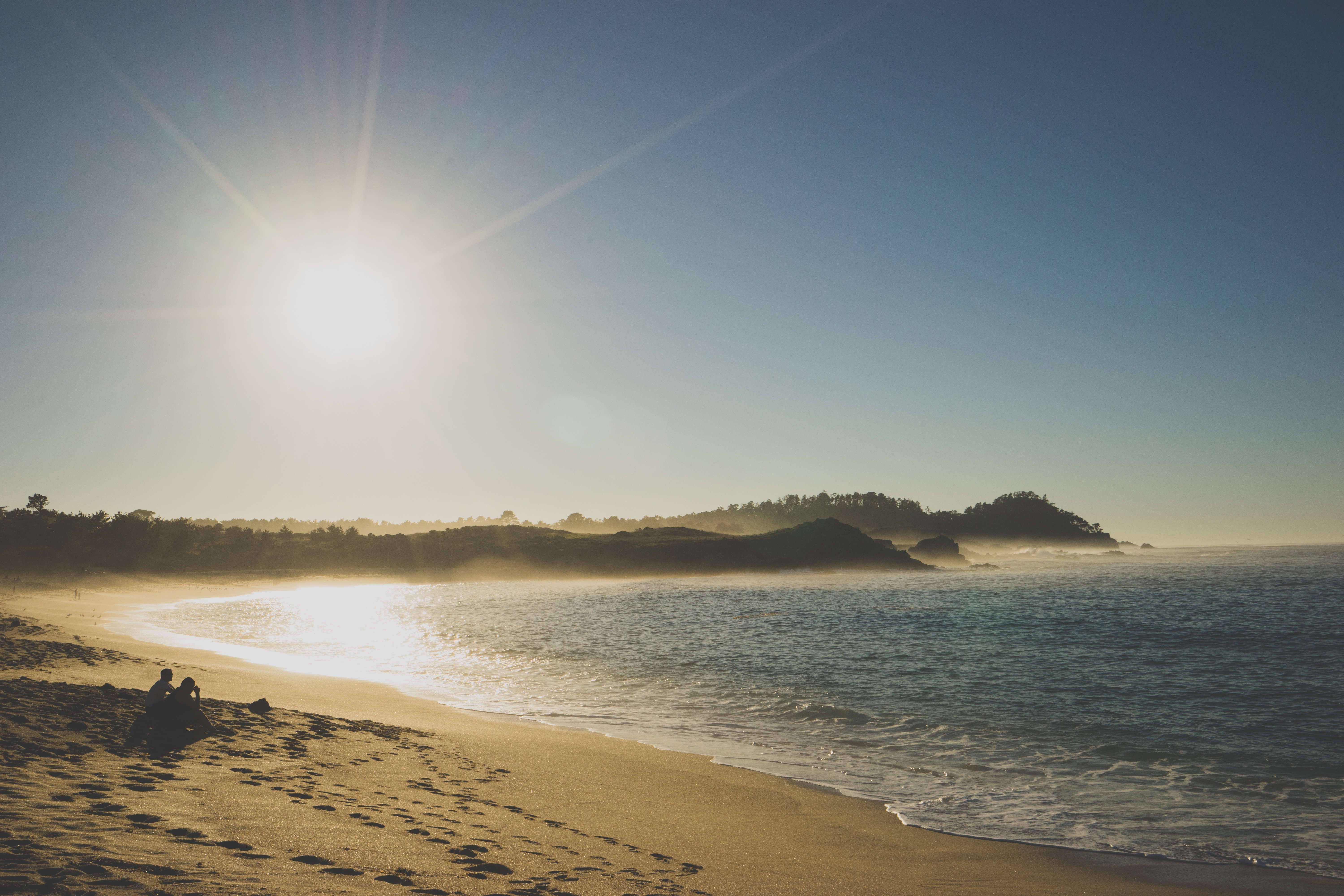 Beach with two people at sunset HD Wallpaper