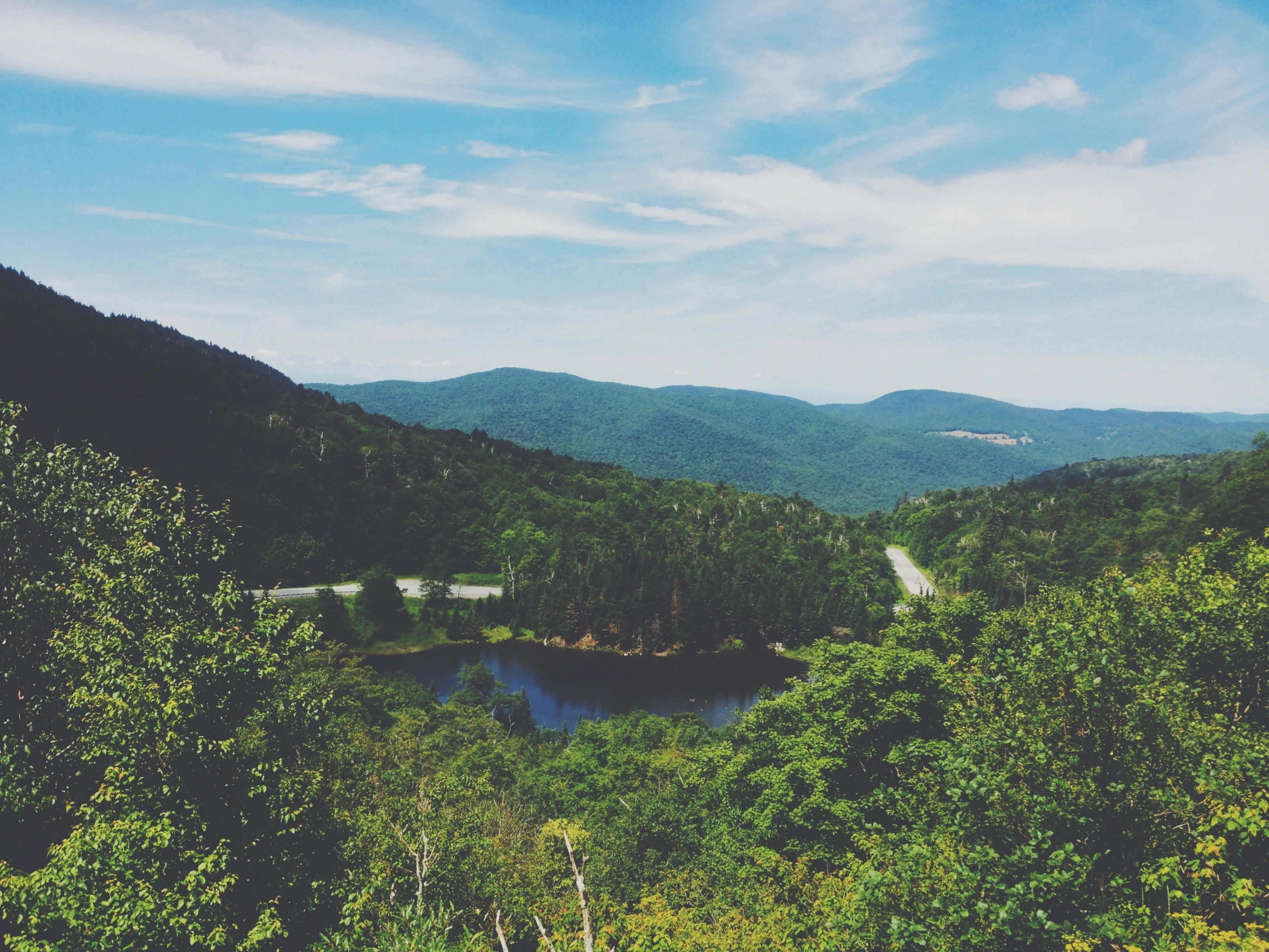 Scenic mountain landscape with a lake and road HD Wallpaper