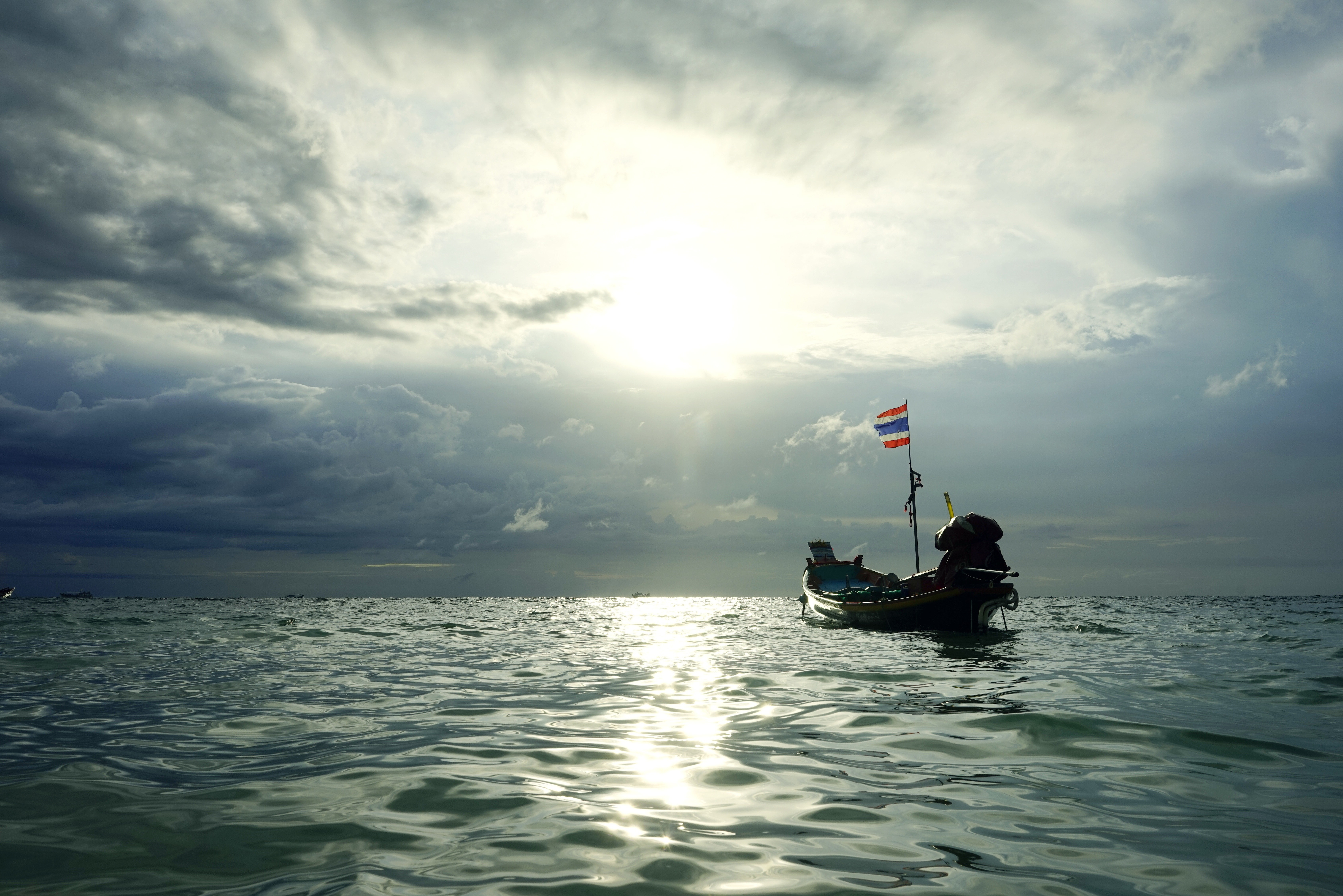 Boat with Thai flag on the sea under cloudy sky HD Wallpaper