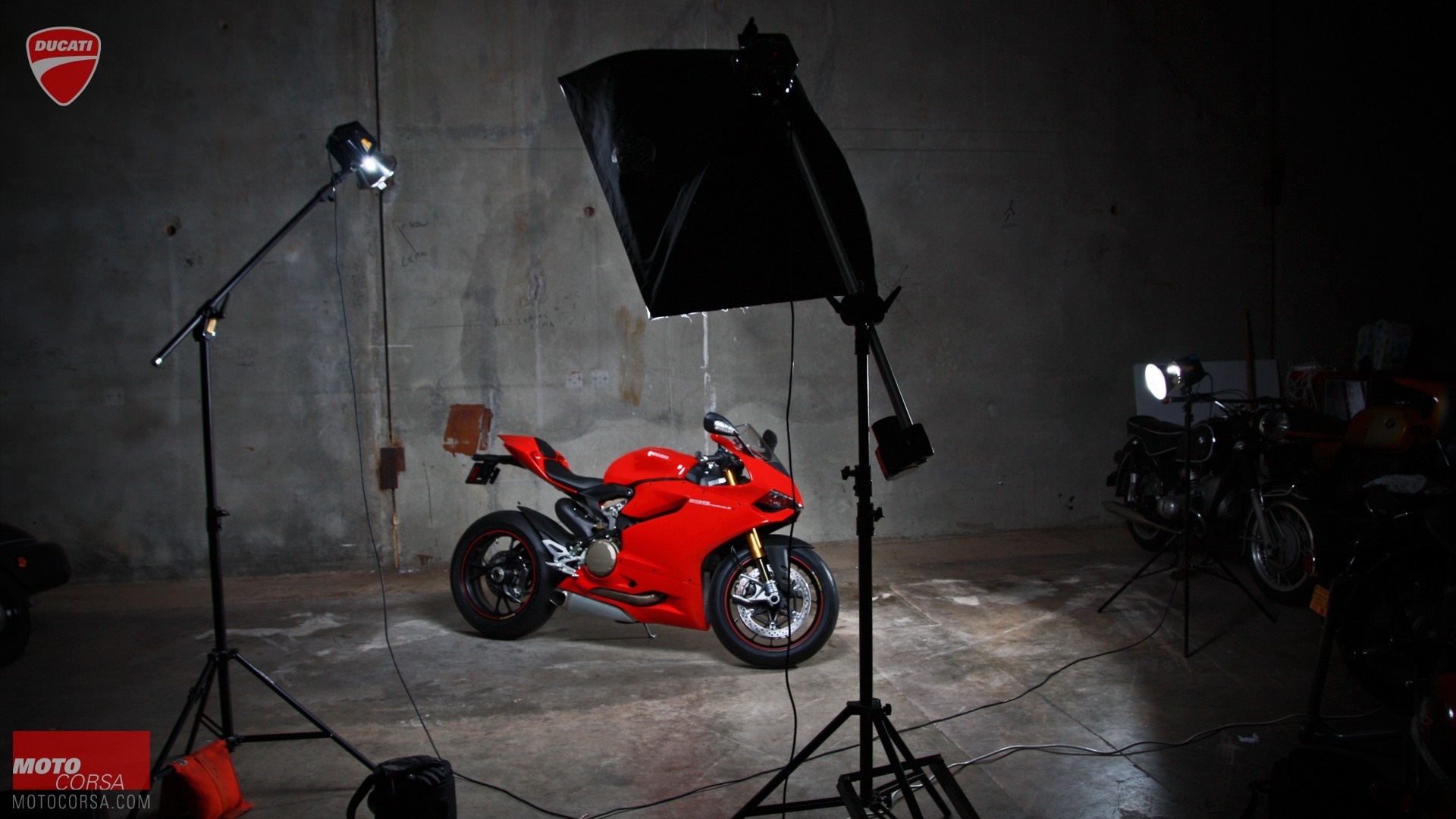 Red Ducati motorcycle in a studio with lighting equipment HD Wallpaper