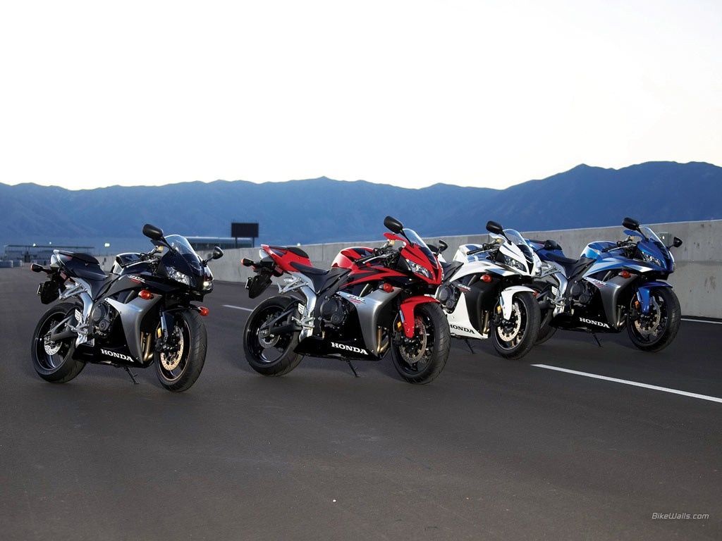 Four Honda CBR sport motorcycles lined up on a road HD Wallpaper