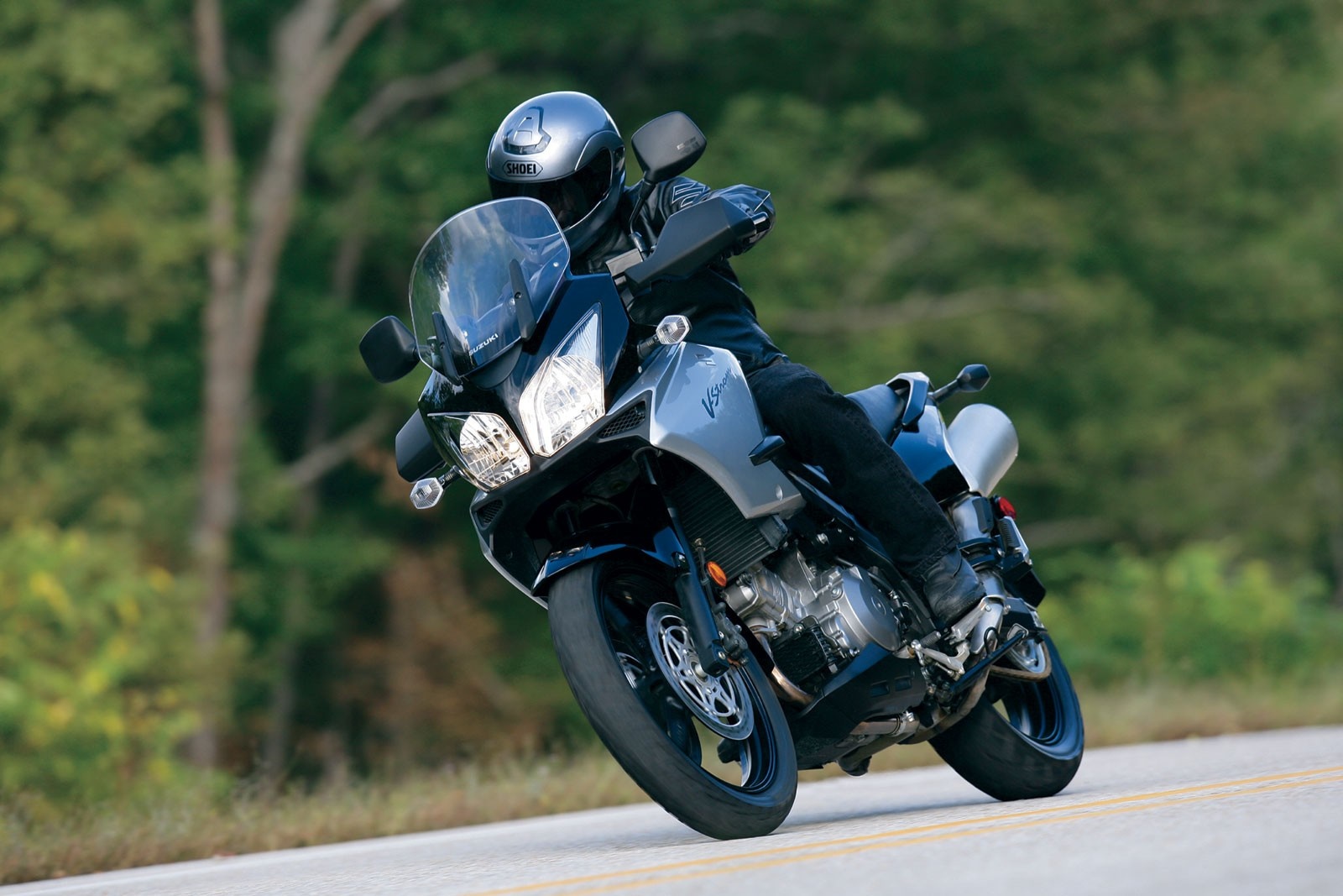 Suzuki V-Strom motorcycle with rider on a road HD Wallpaper