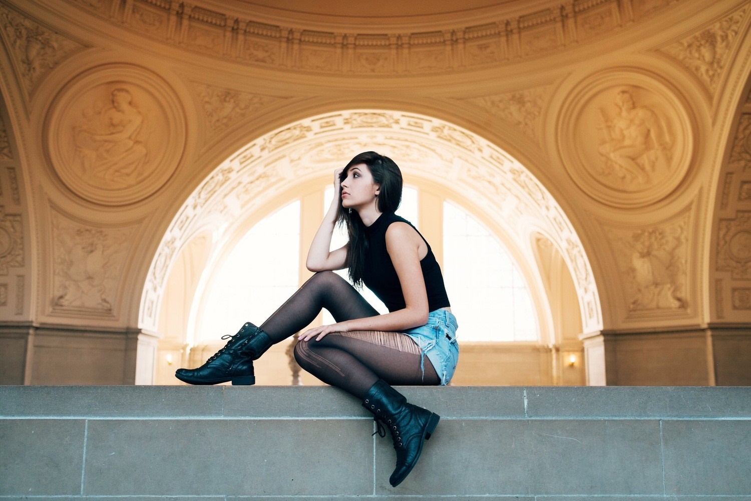 Stylish Woman Sitting with Boots and Denim Shorts HD Wallpaper