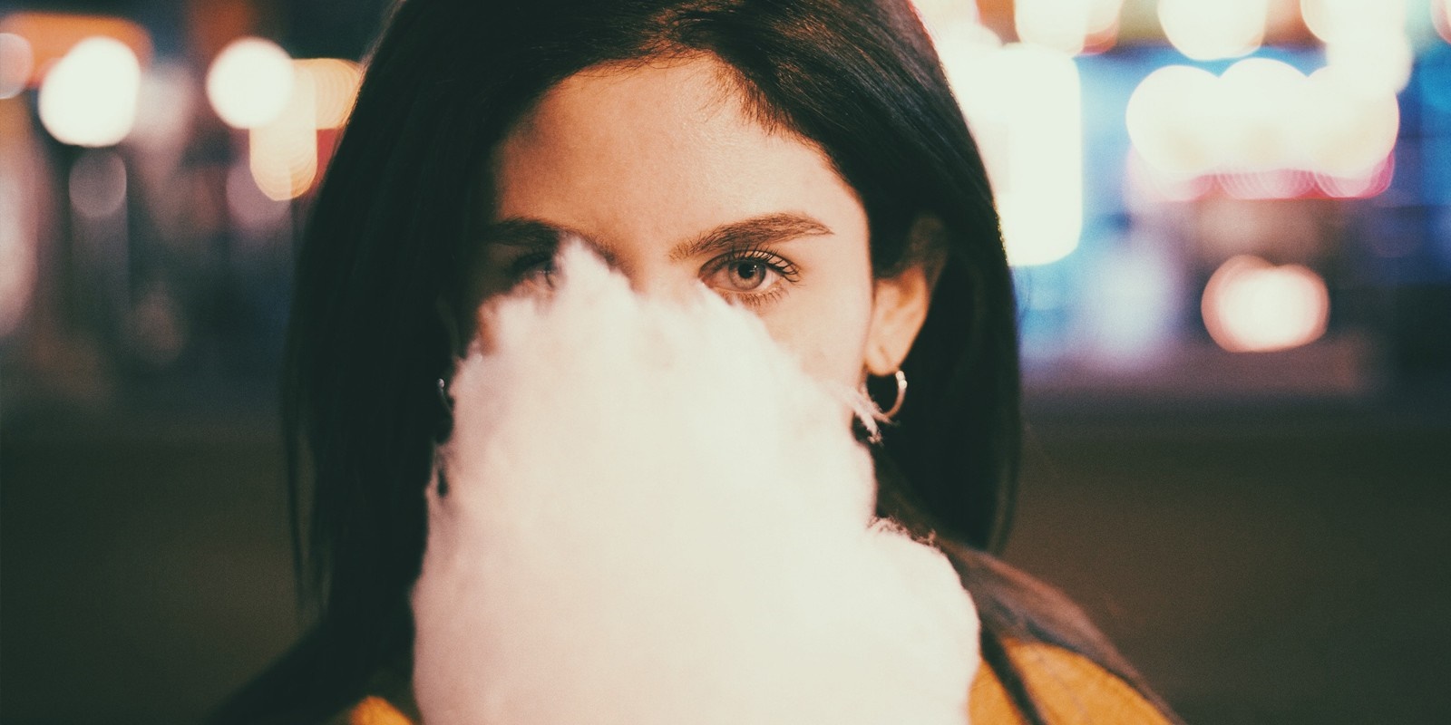 Woman holding cotton candy in front of her face HD Wallpaper