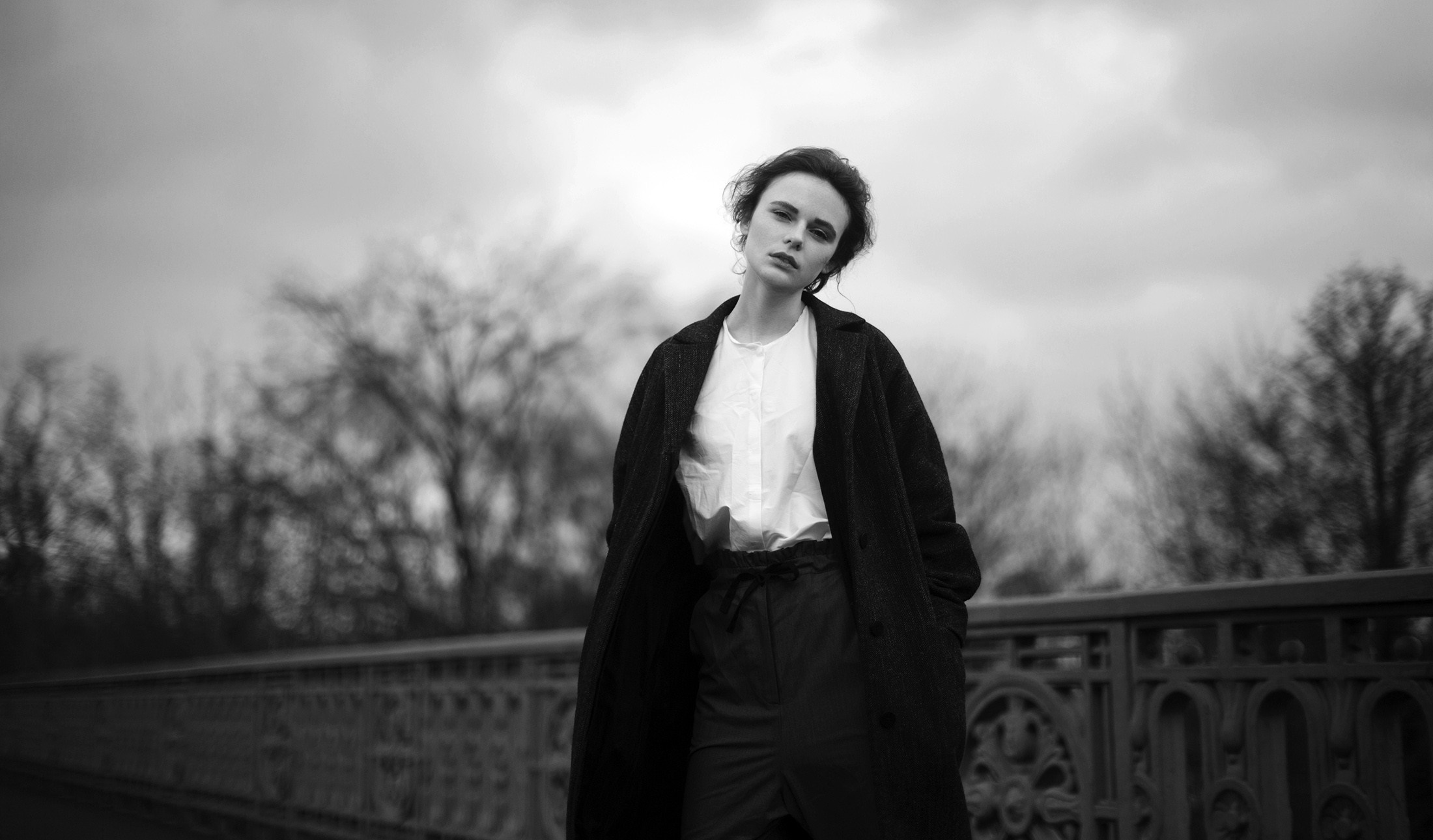 Woman in coat and white shirt on a bridge HD Wallpaper