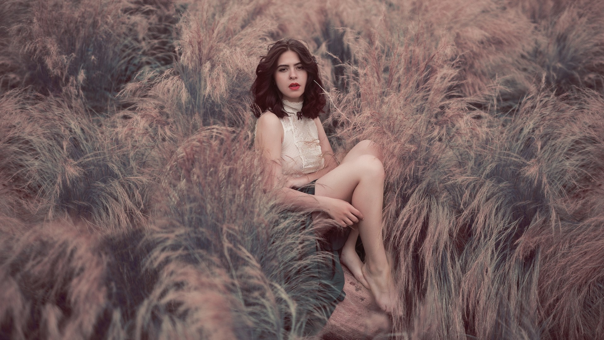 Woman sitting in a field of tall grass HD Wallpaper