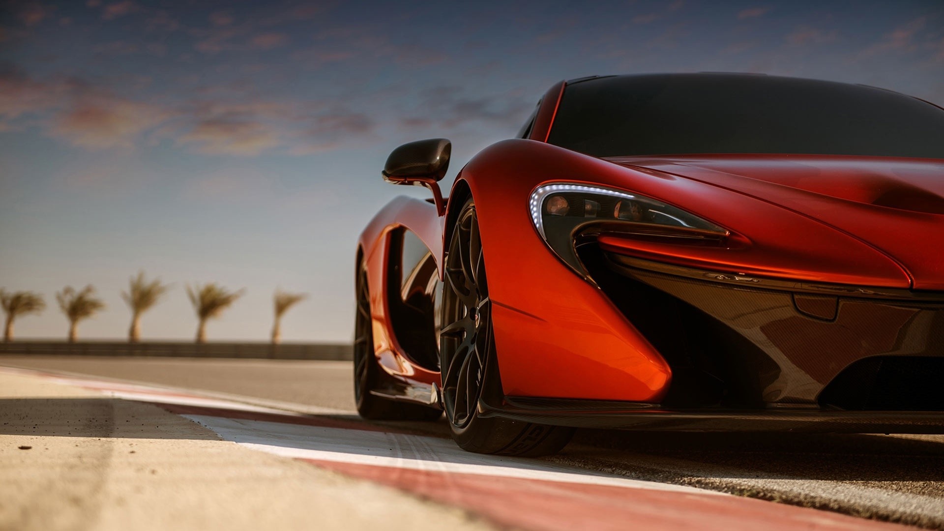 Red McLaren P1 sports car on a race track HD Wallpaper