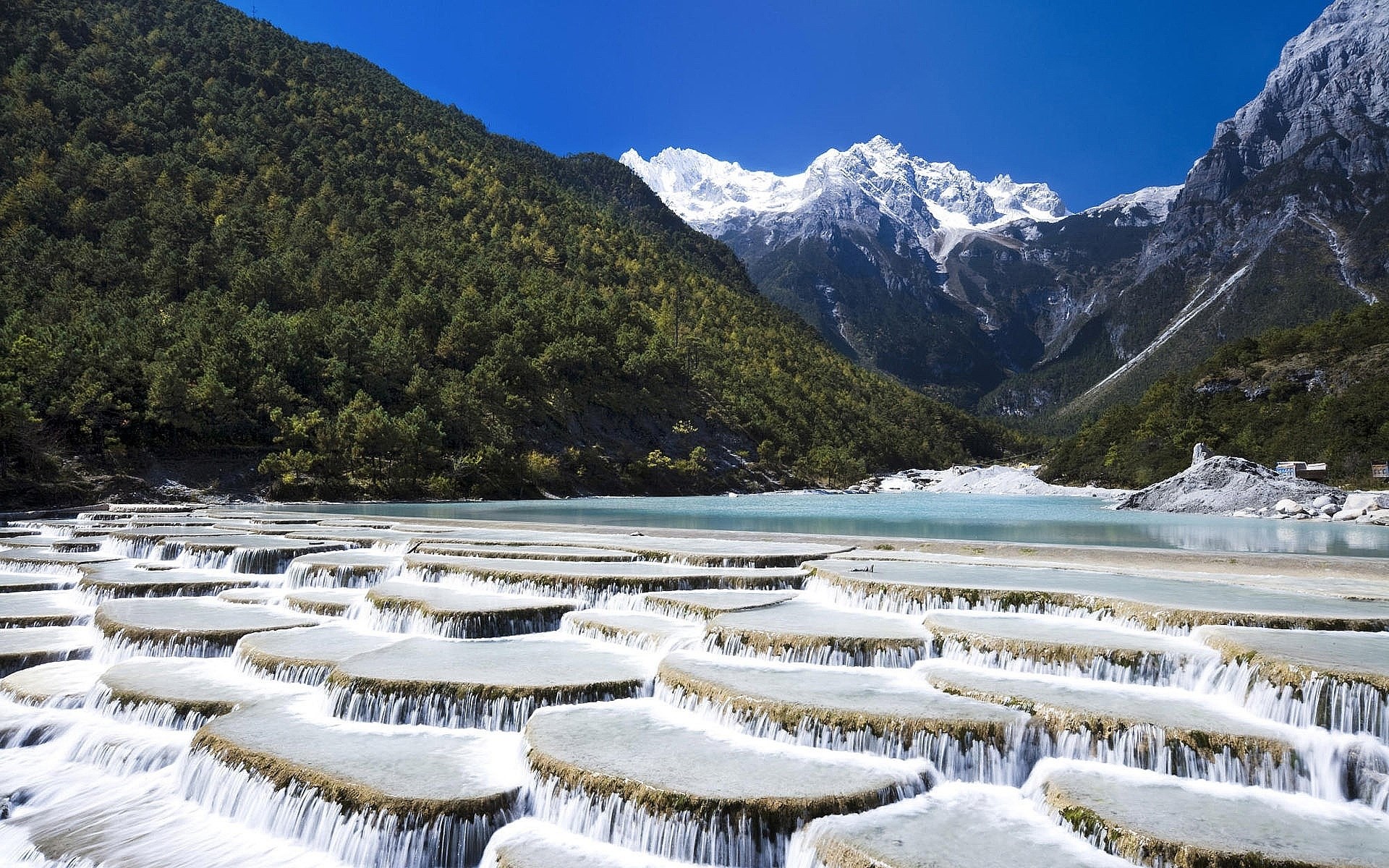 Terraced waterfalls and snow-capped mountains HD Wallpaper