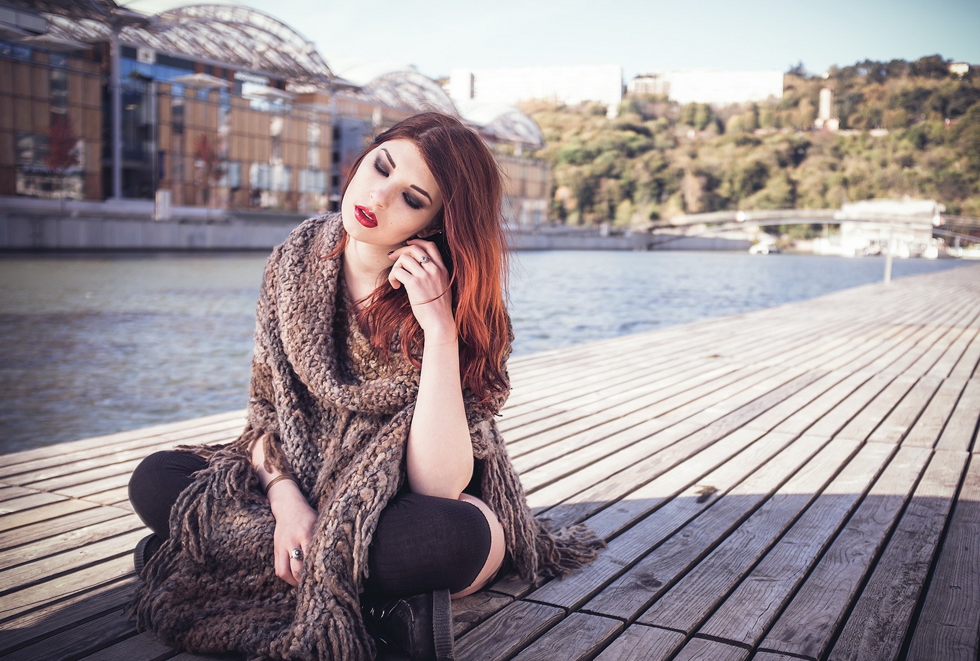 Woman with long brown hair wearing a shawl sitting by water HD Wallpaper