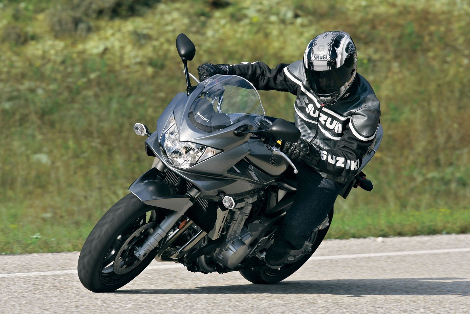 Suzuki motorcycle rider on a road HD Wallpaper