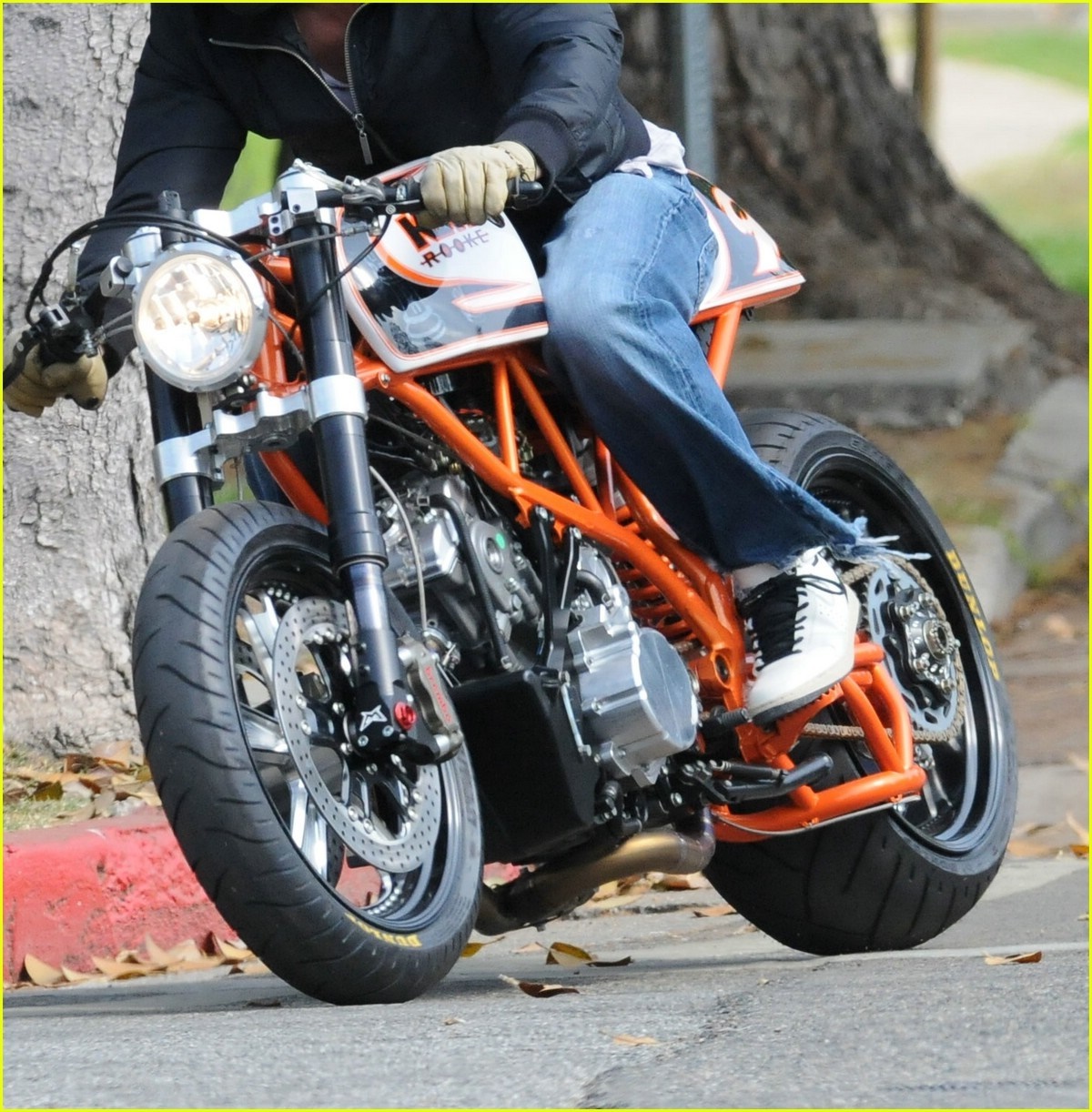 Person riding a custom orange motorcycle HD Wallpaper