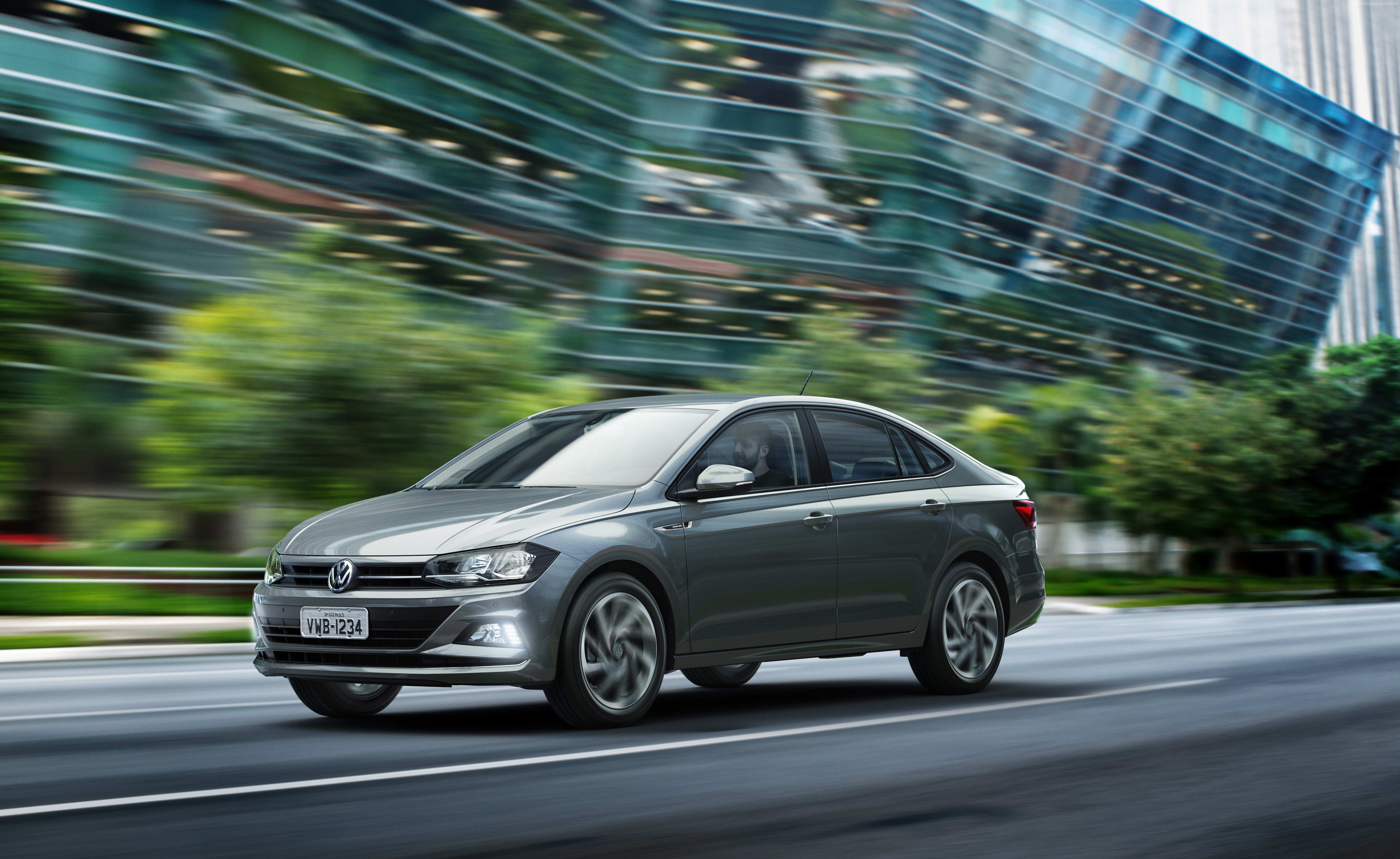 Volkswagen Virtus driving on a city street HD Wallpaper