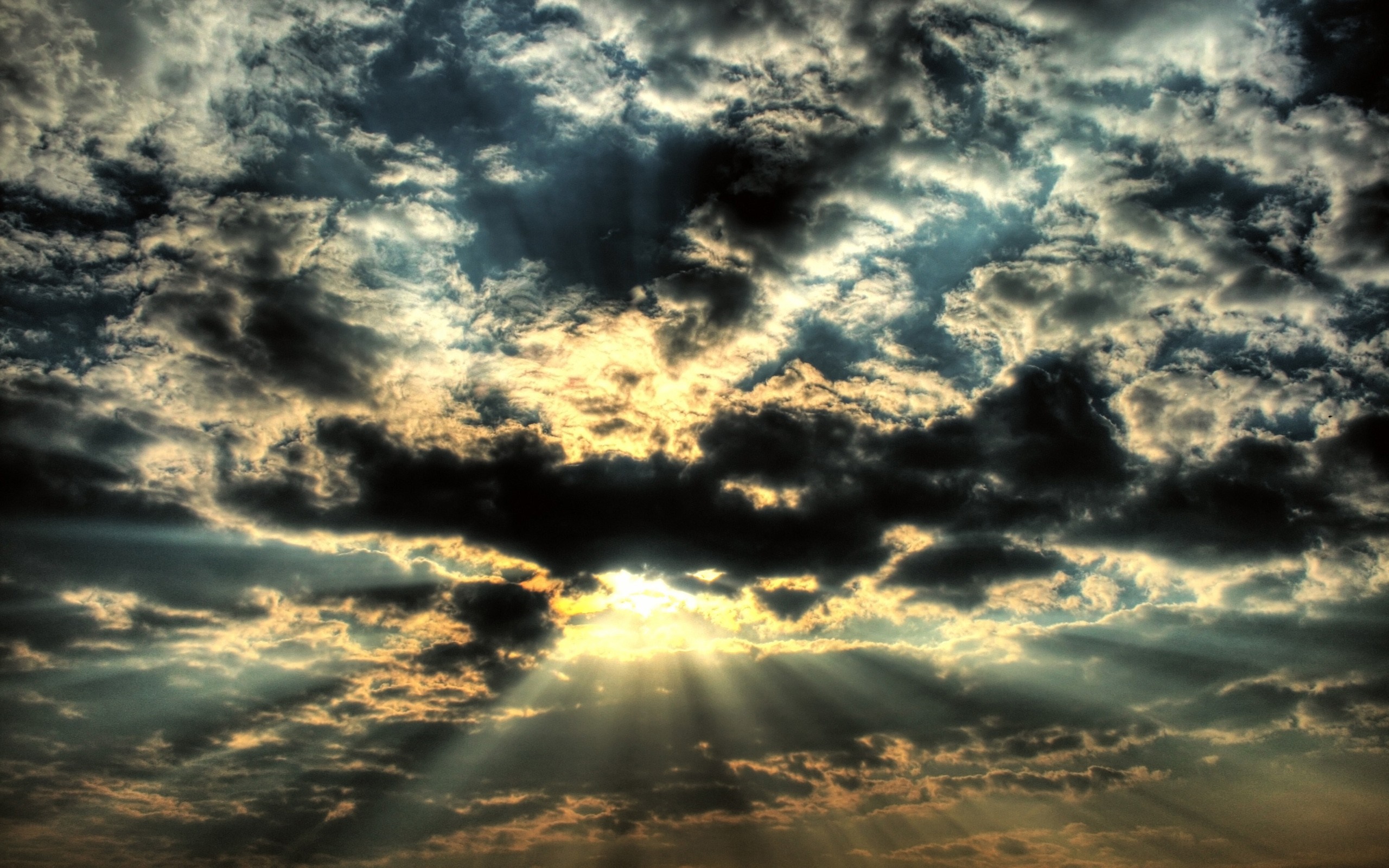 Sunlight beams through dark clouds at sunset HD Wallpaper