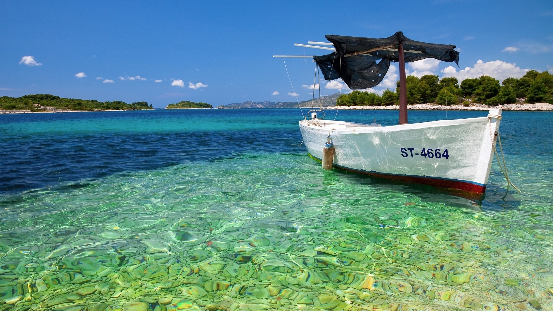 White boat moored in clear turquoise water near islands HD Wallpaper
