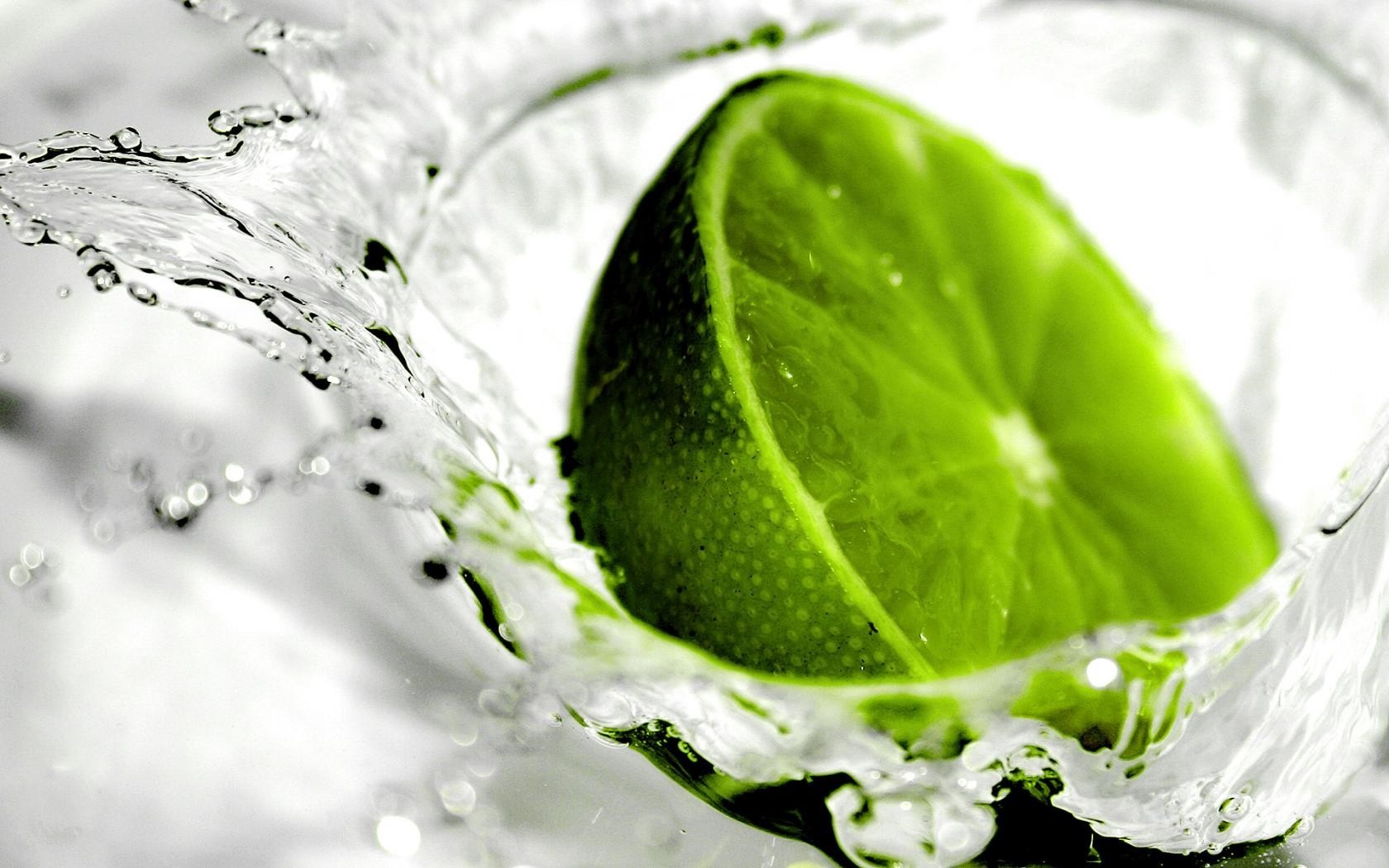 Close-up of a lime slice splashing into water HD Wallpaper