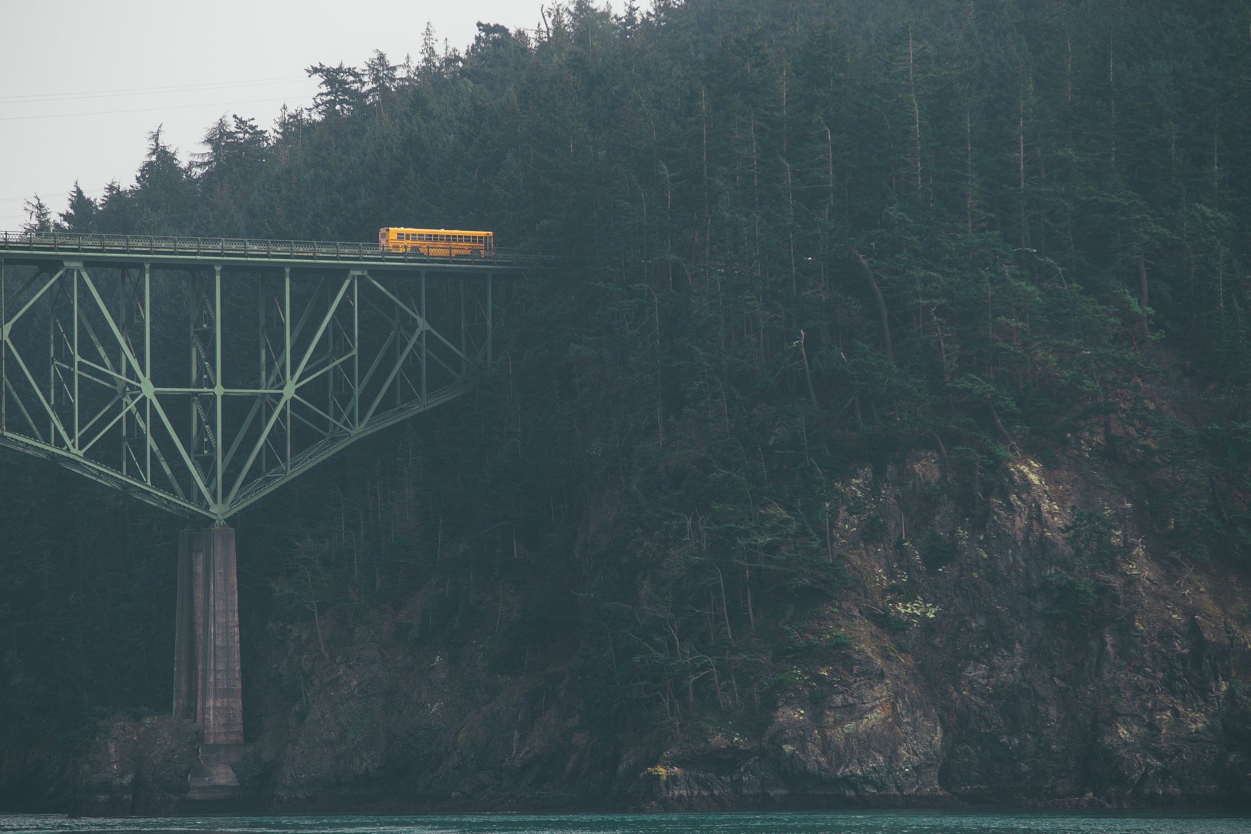 Yellow school bus on a bridge over water HD Wallpaper