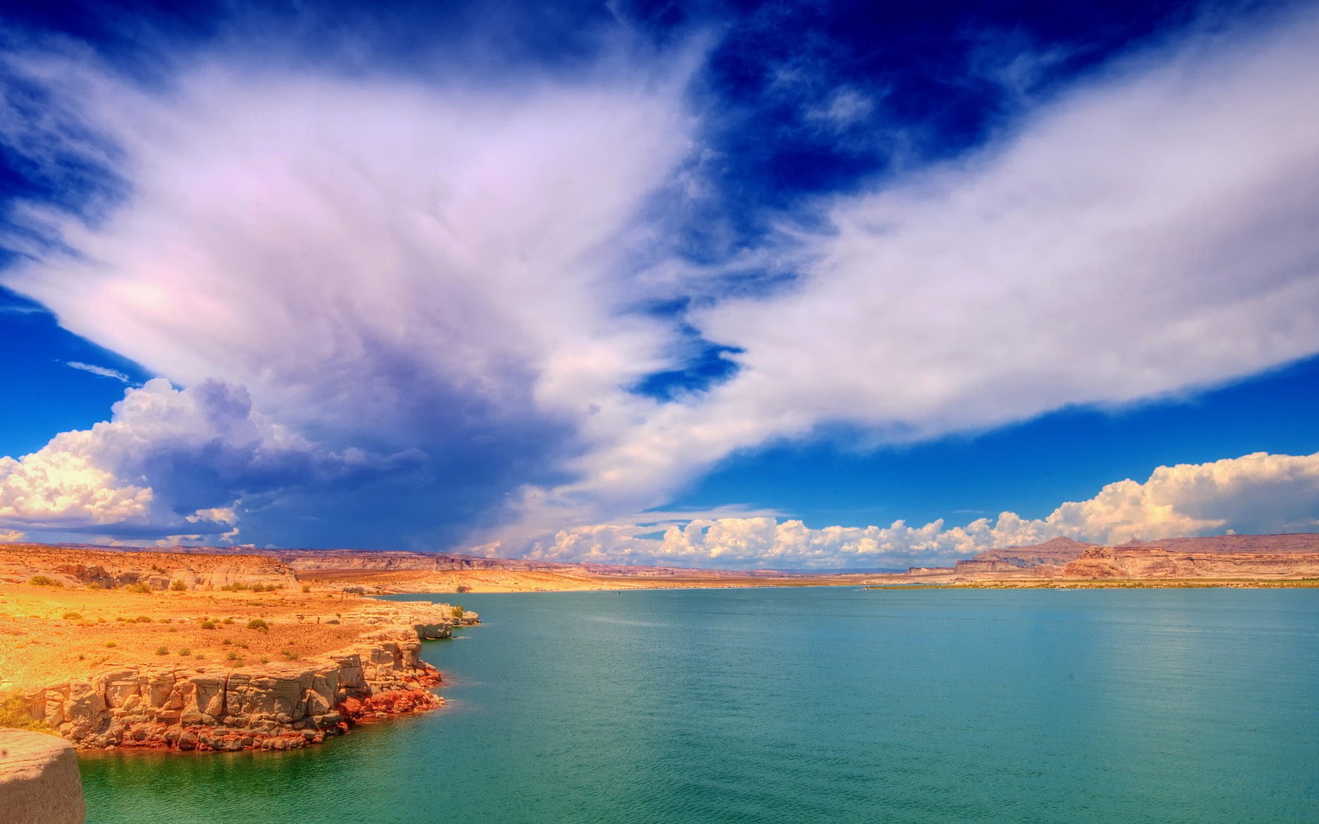 Desert landscape with a large body of water and dramatic clouds HD Wallpaper