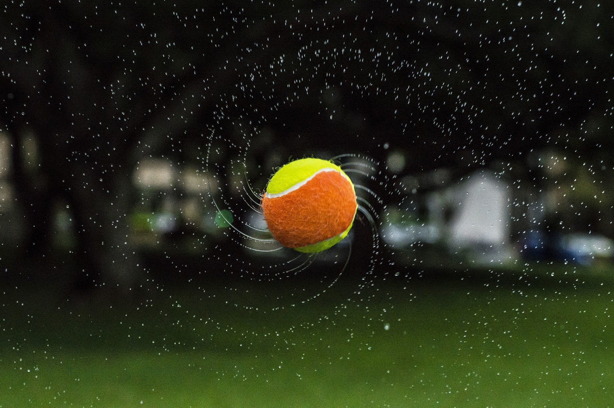 Tennis ball spinning with water droplets HD Wallpaper