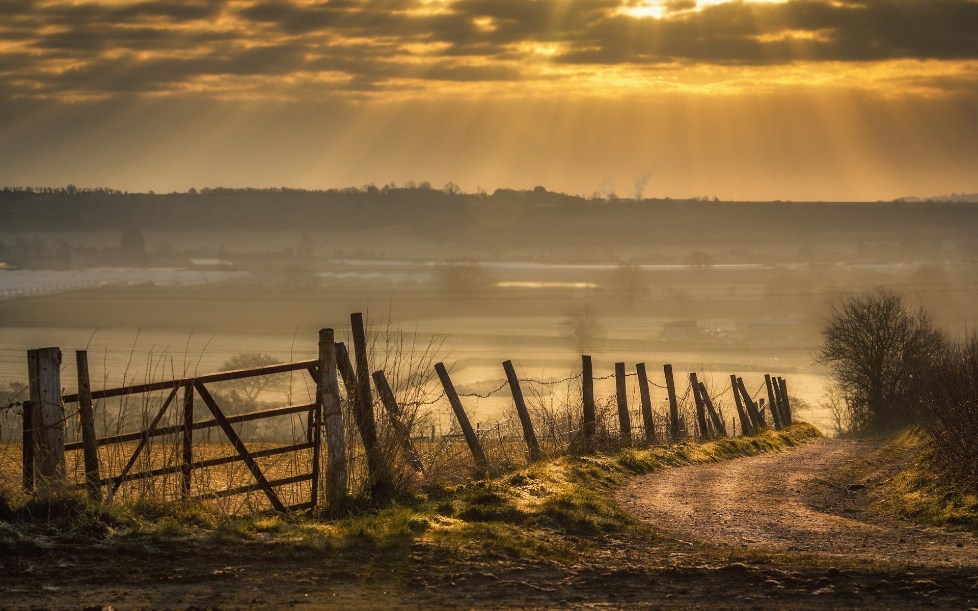 Rural landscape with a dirt road and fence at sunrise HD Wallpaper