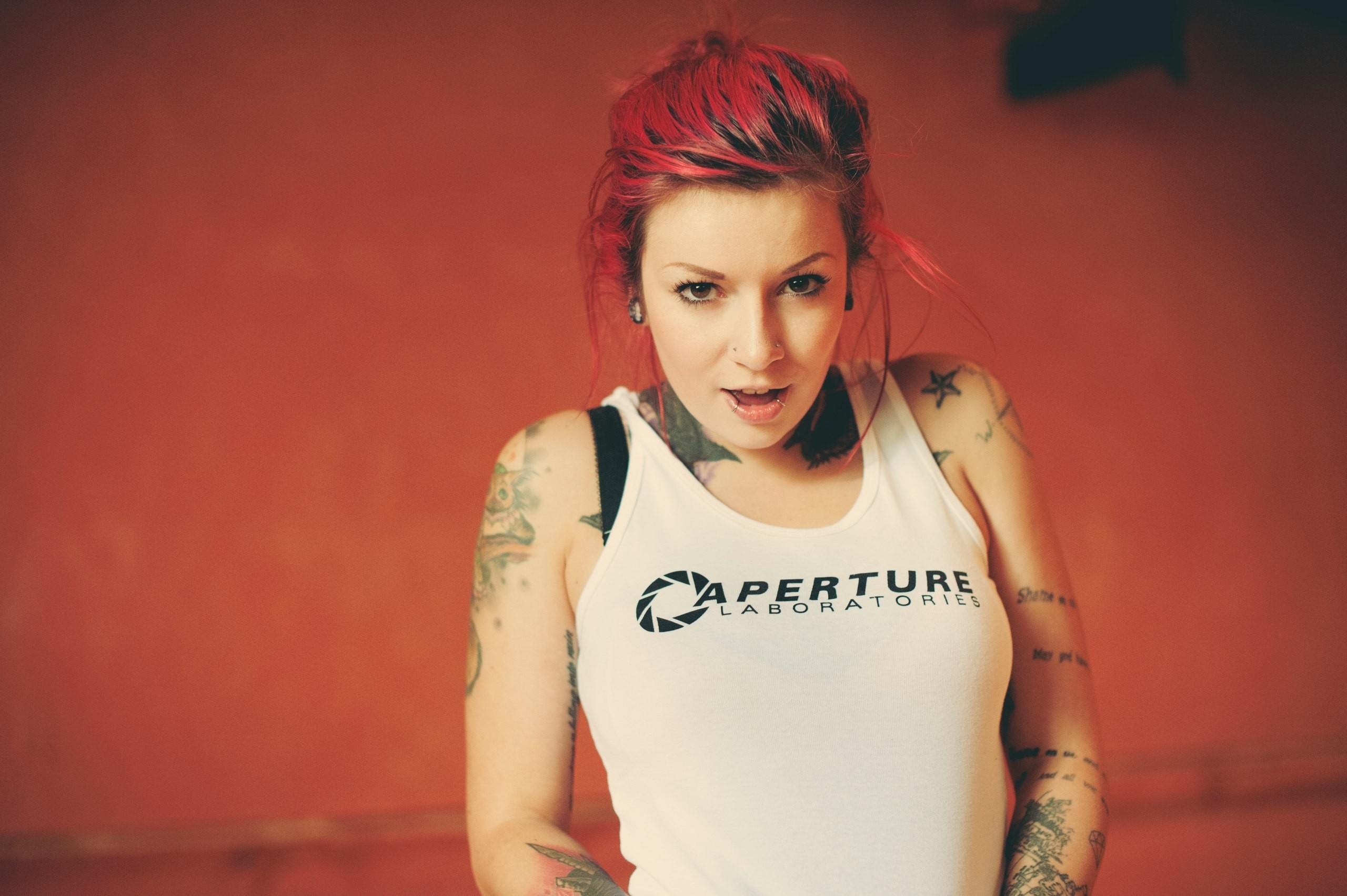 Woman with red hair and tattoos wearing Aperture Laboratories shirt HD Wallpaper