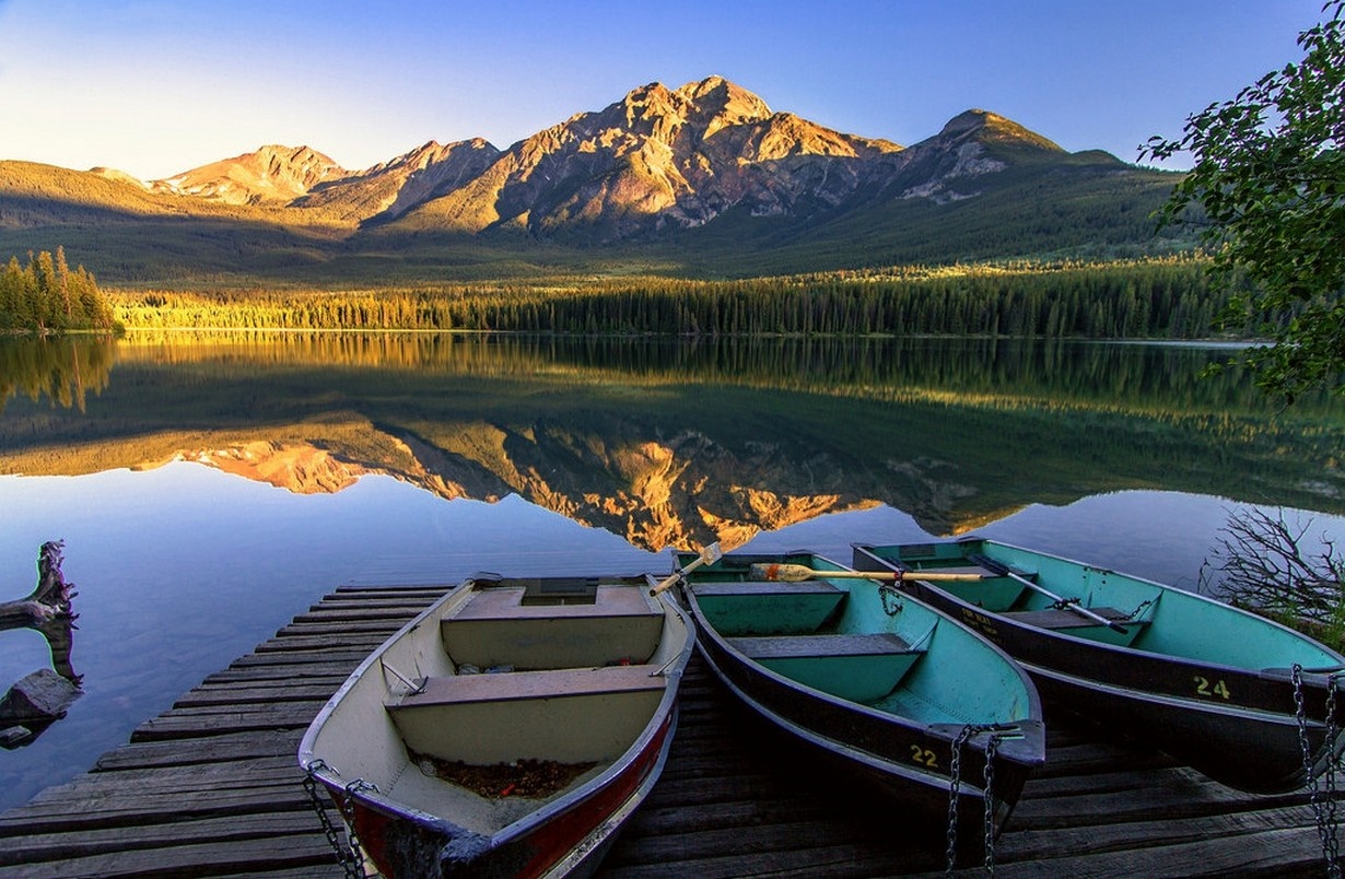 Boats on a lake with mountains and forest reflection HD Wallpaper