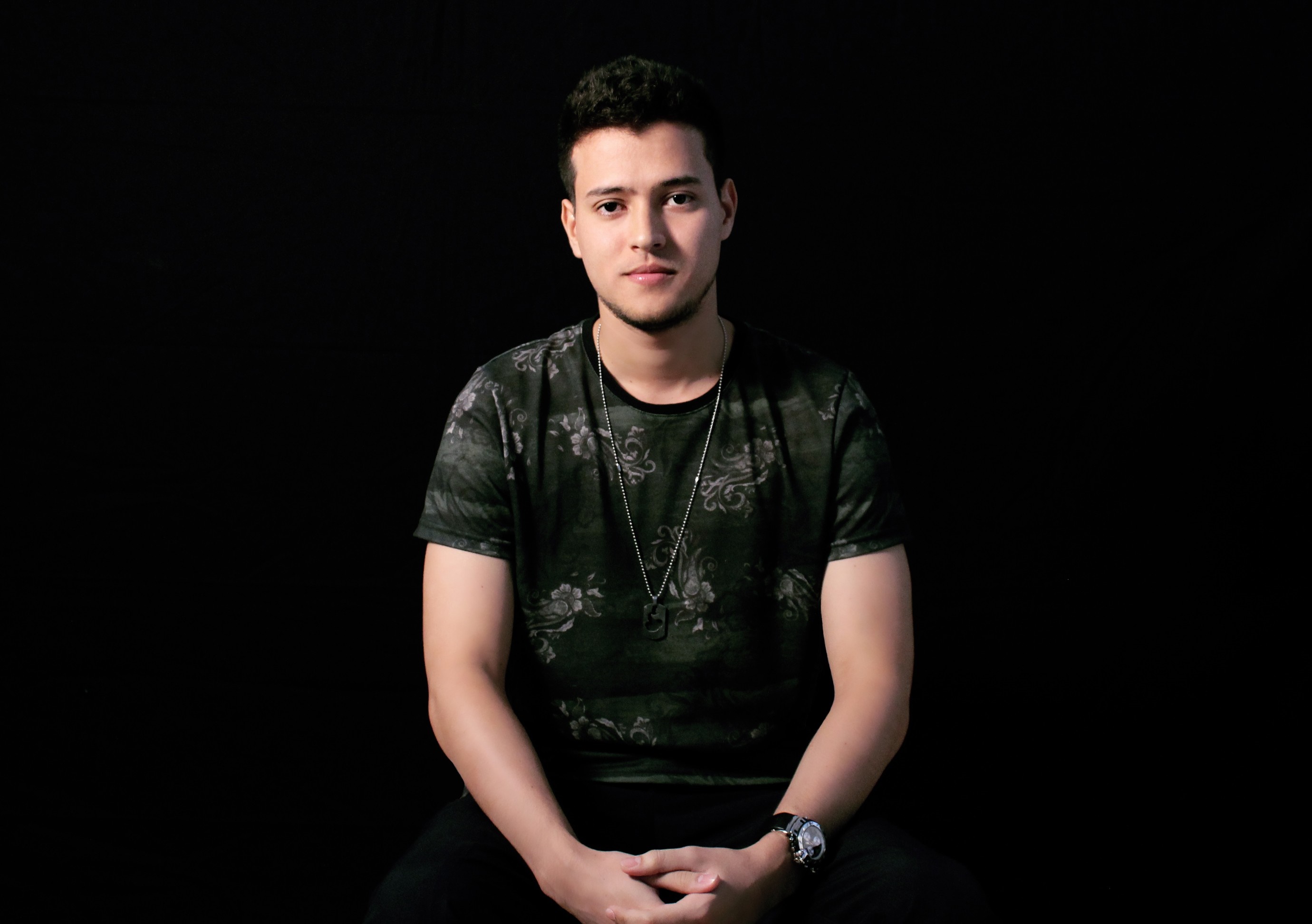 Man in patterned t-shirt and necklace HD Wallpaper