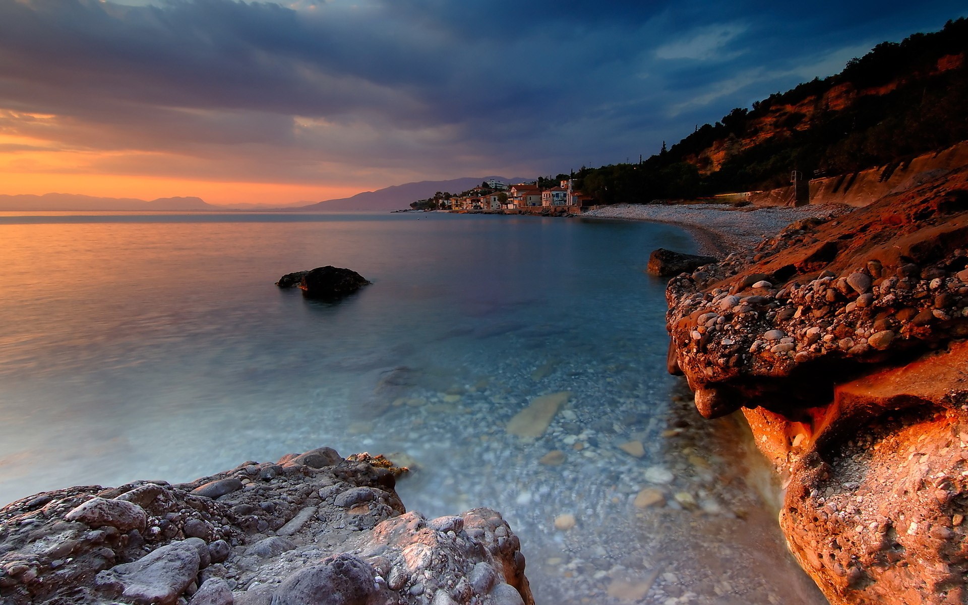 Coastal village at sunset with rocky shore HD Wallpaper