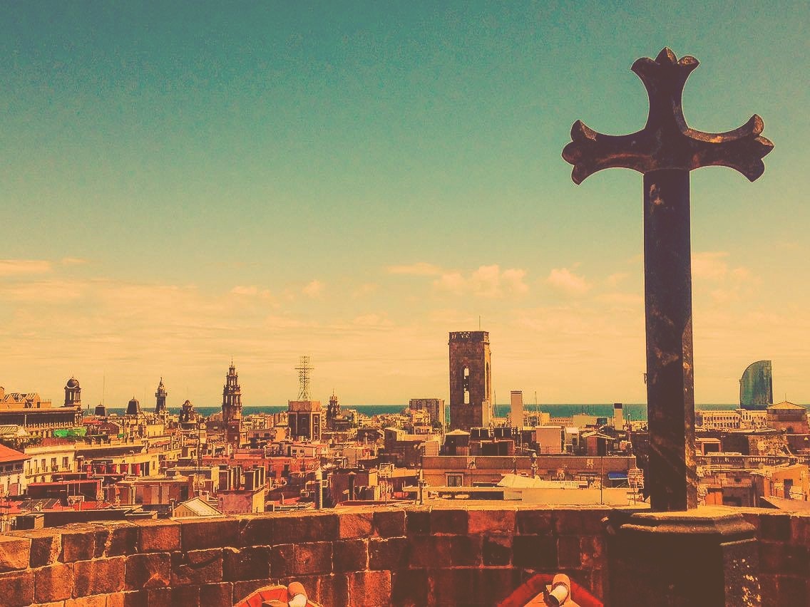 Cross overlooking Barcelona cityscape at sunset HD Wallpaper