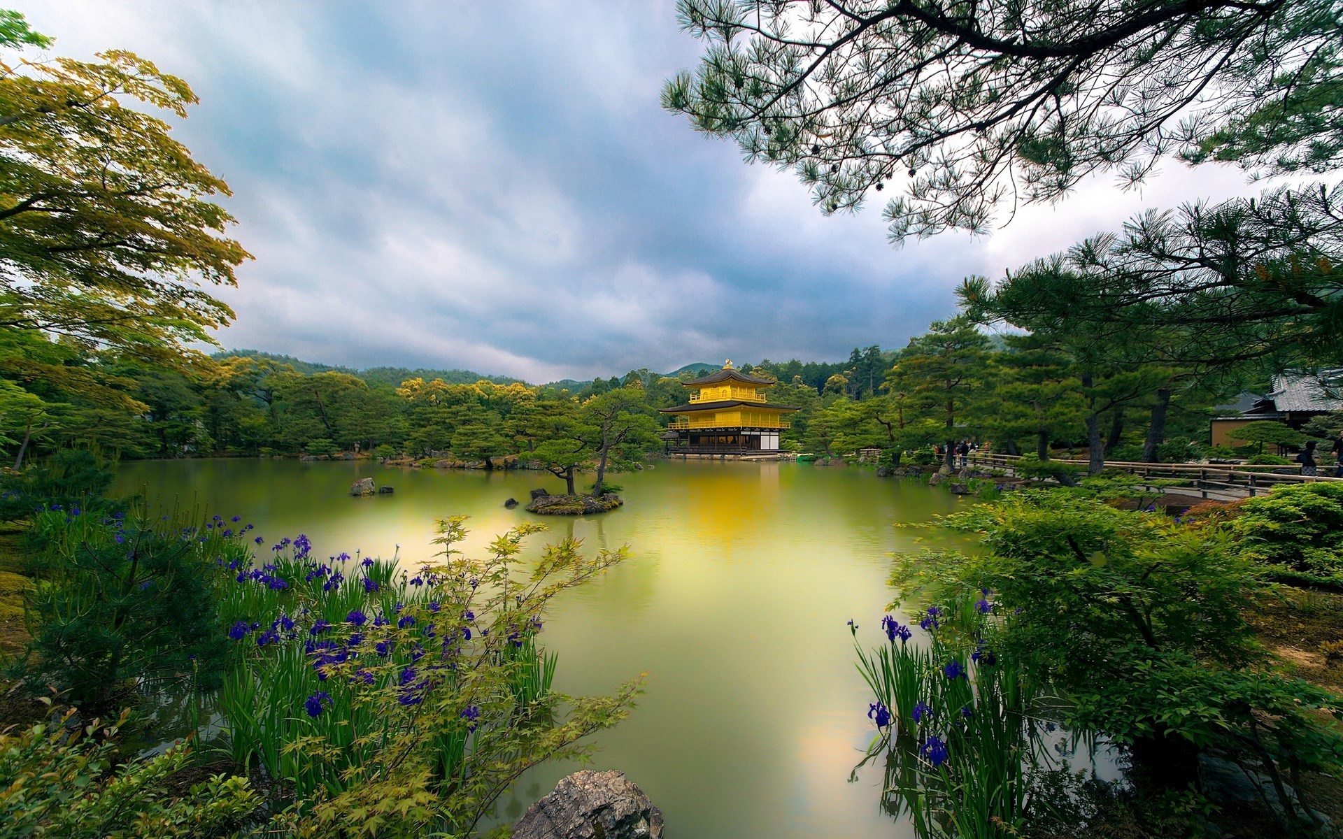 Golden Pavilion reflected in a pond with surrounding trees and flowers HD Wallpaper