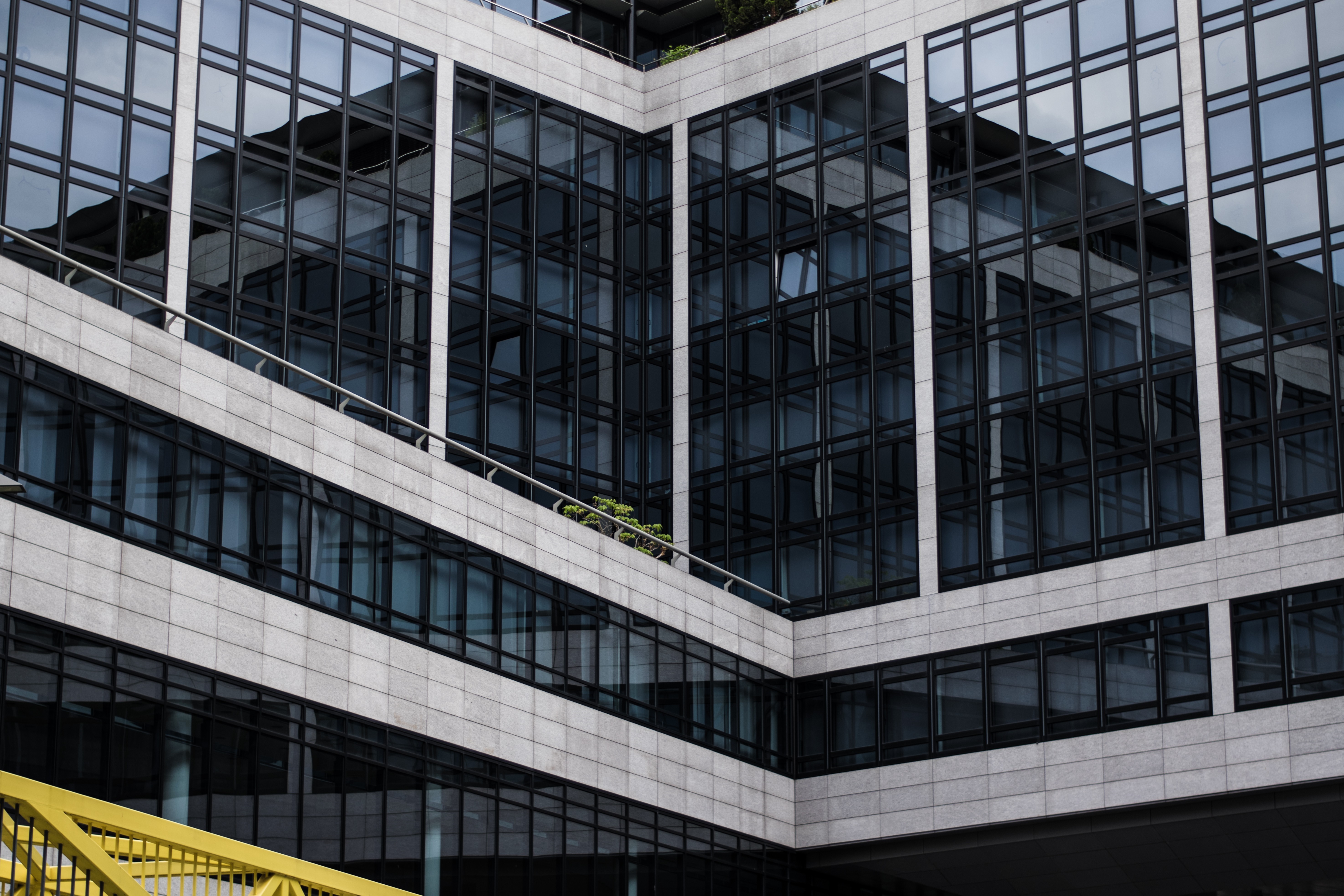 Modern building facade with glass windows and concrete elements HD Wallpaper
