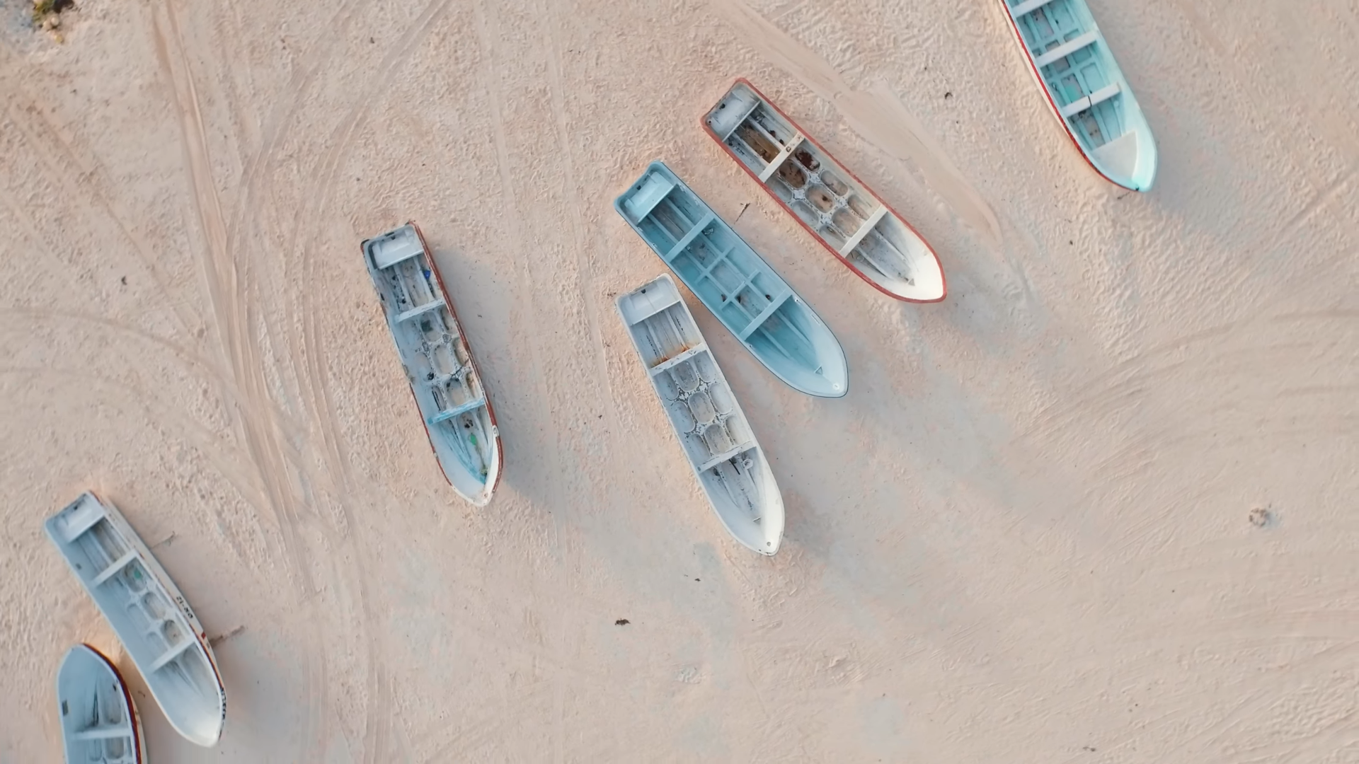 Several boats resting on a sandy beach HD Wallpaper