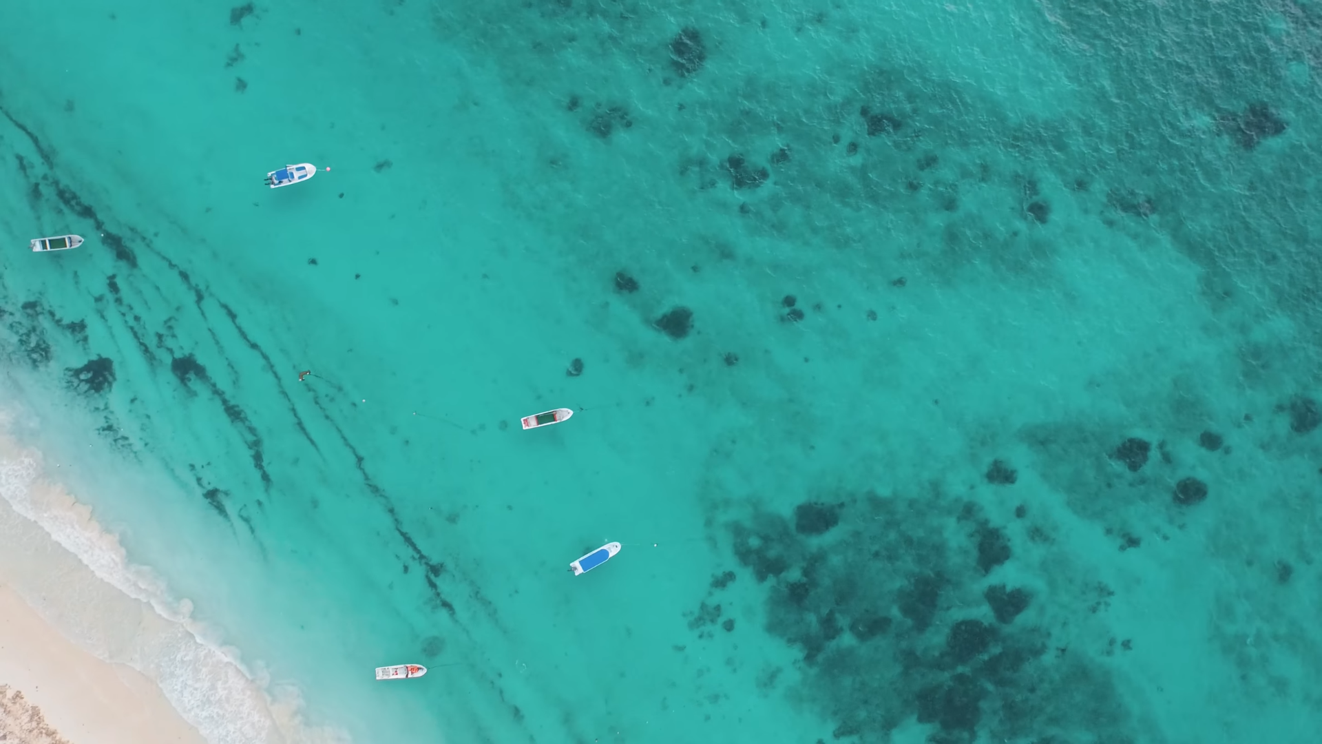 Aerial view of boats on turquoise water near a sandy beach HD Wallpaper
