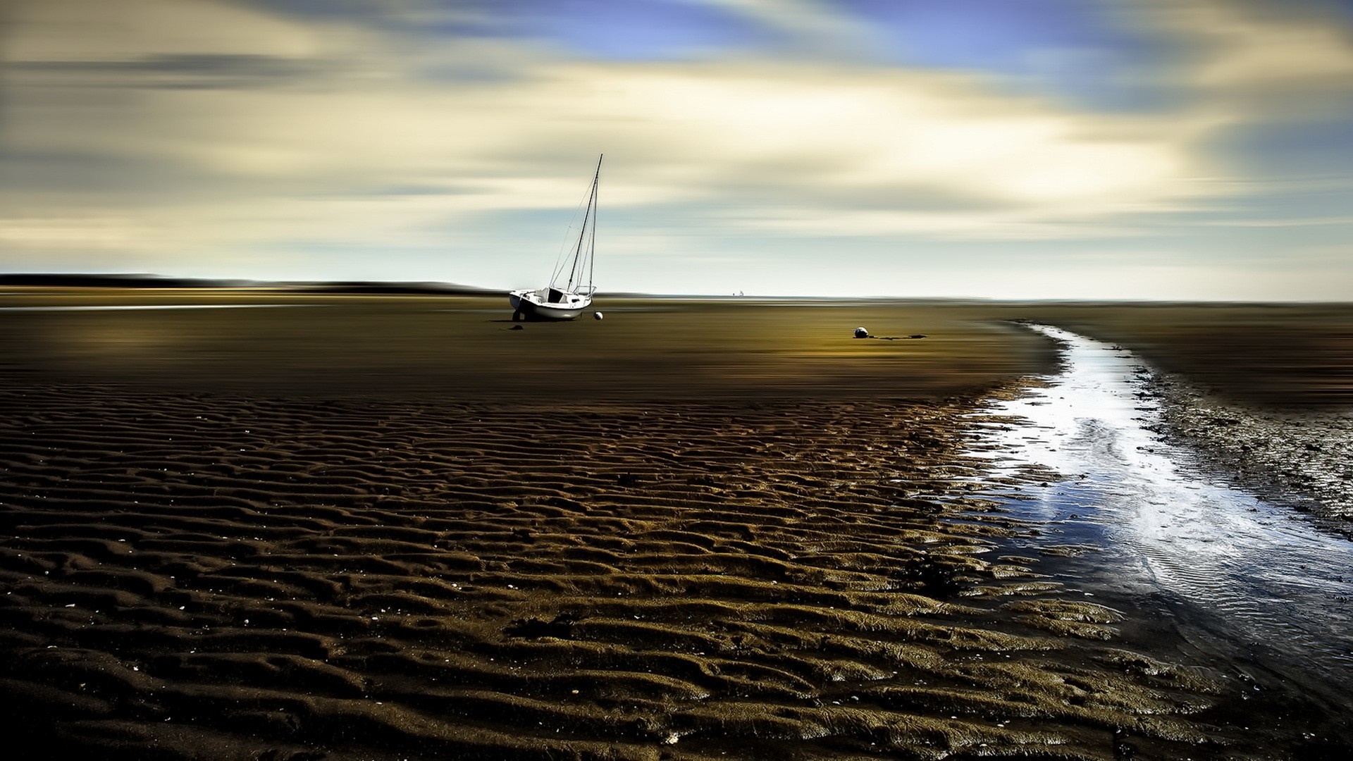 Sailboat on a mudflat with a stream HD Wallpaper