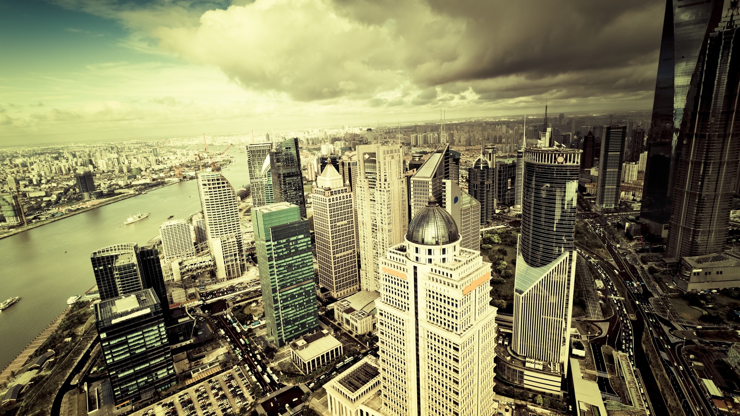 Aerial view of a modern city skyline with skyscrapers and a river HD Wallpaper
