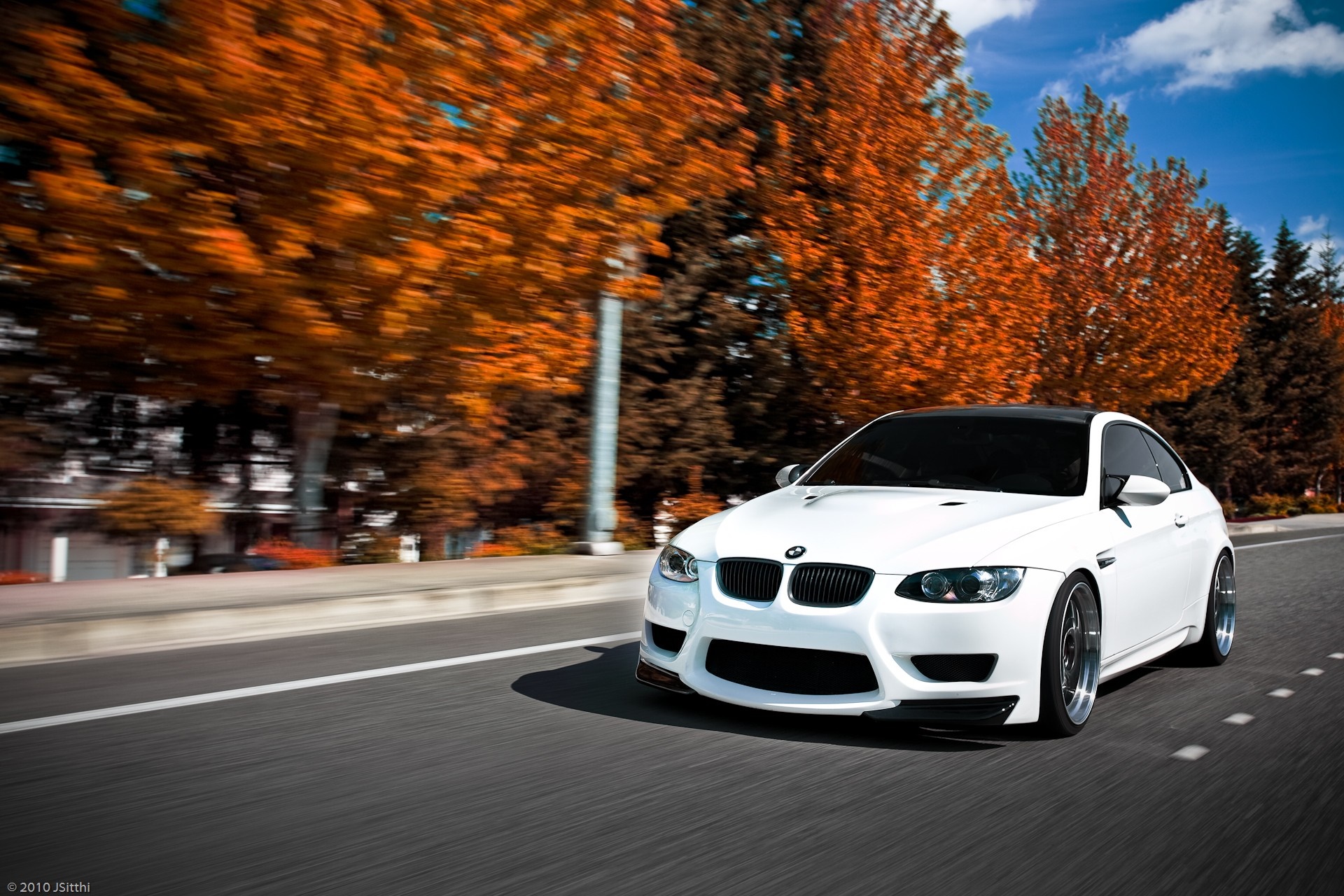 White BMW M3 Coupe driving on a road with autumn trees HD Wallpaper