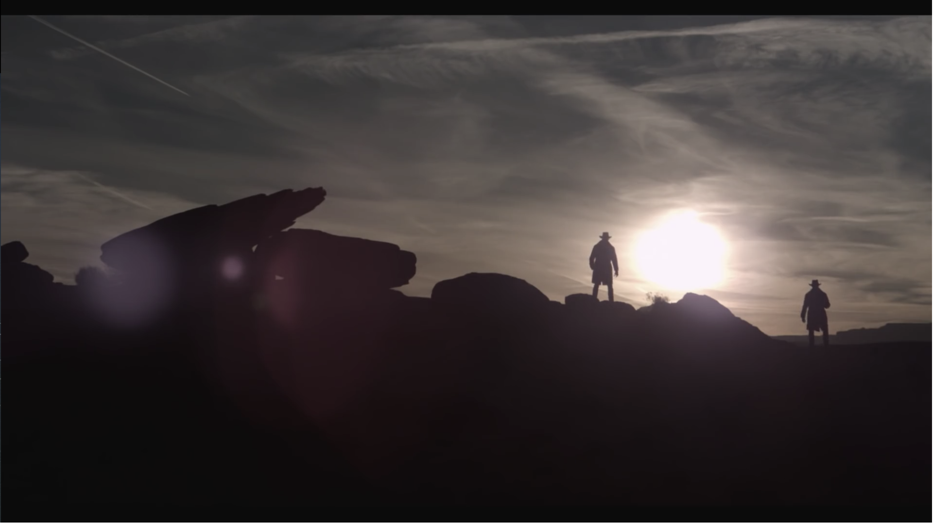 Two figures silhouetted against the sun at sunset HD Wallpaper