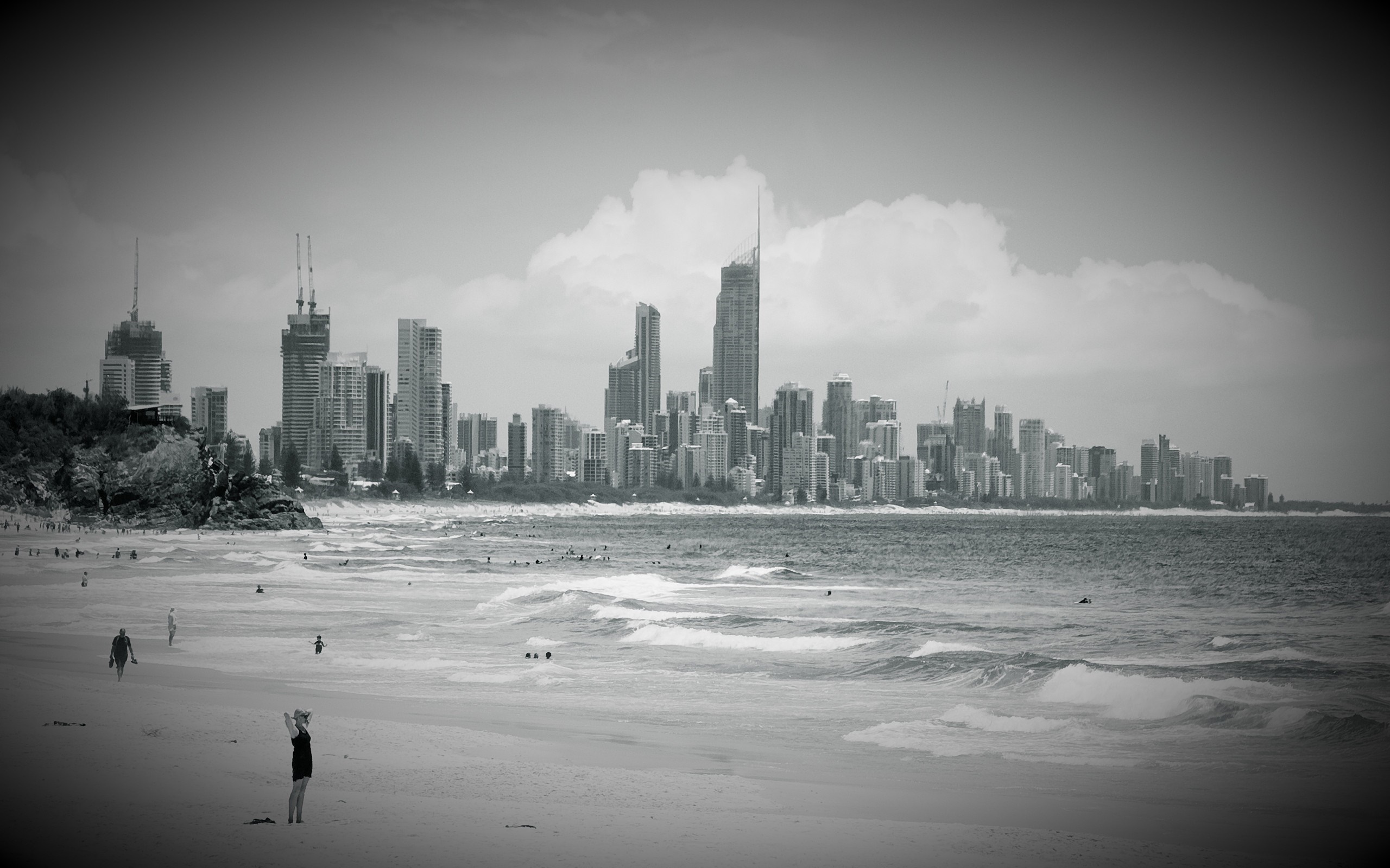 Monochrome cityscape with beach and ocean waves HD Wallpaper