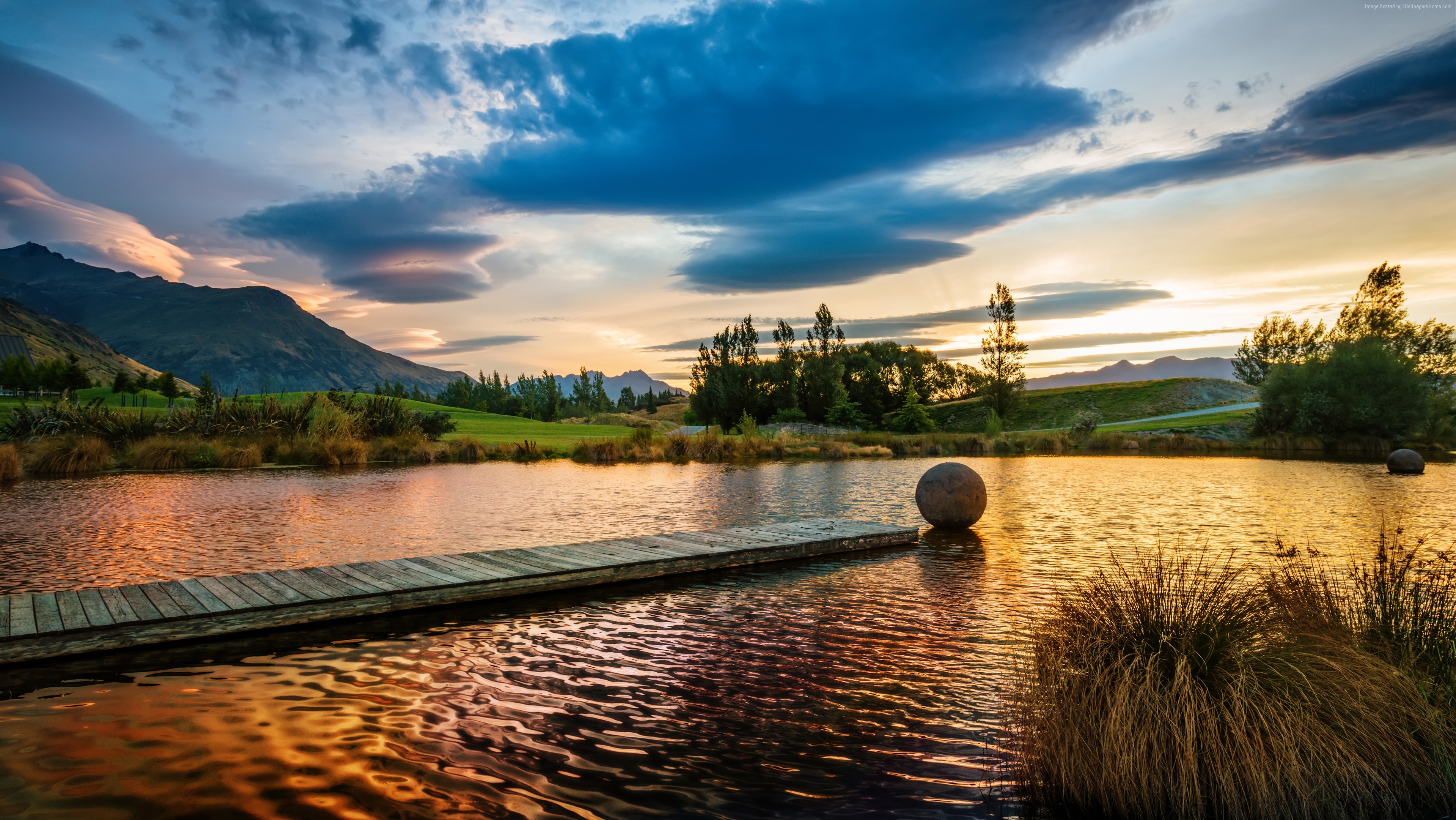 Lake at sunset with mountains and a dock HD Wallpaper