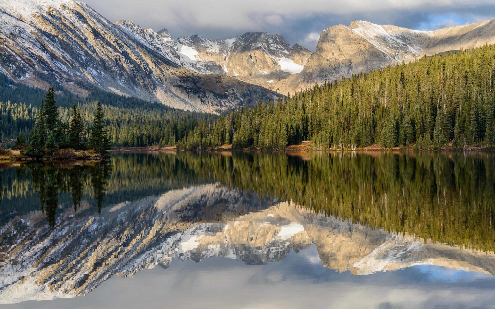 Mountain lake reflection with pine forest and snow-capped peaks HD Wallpaper