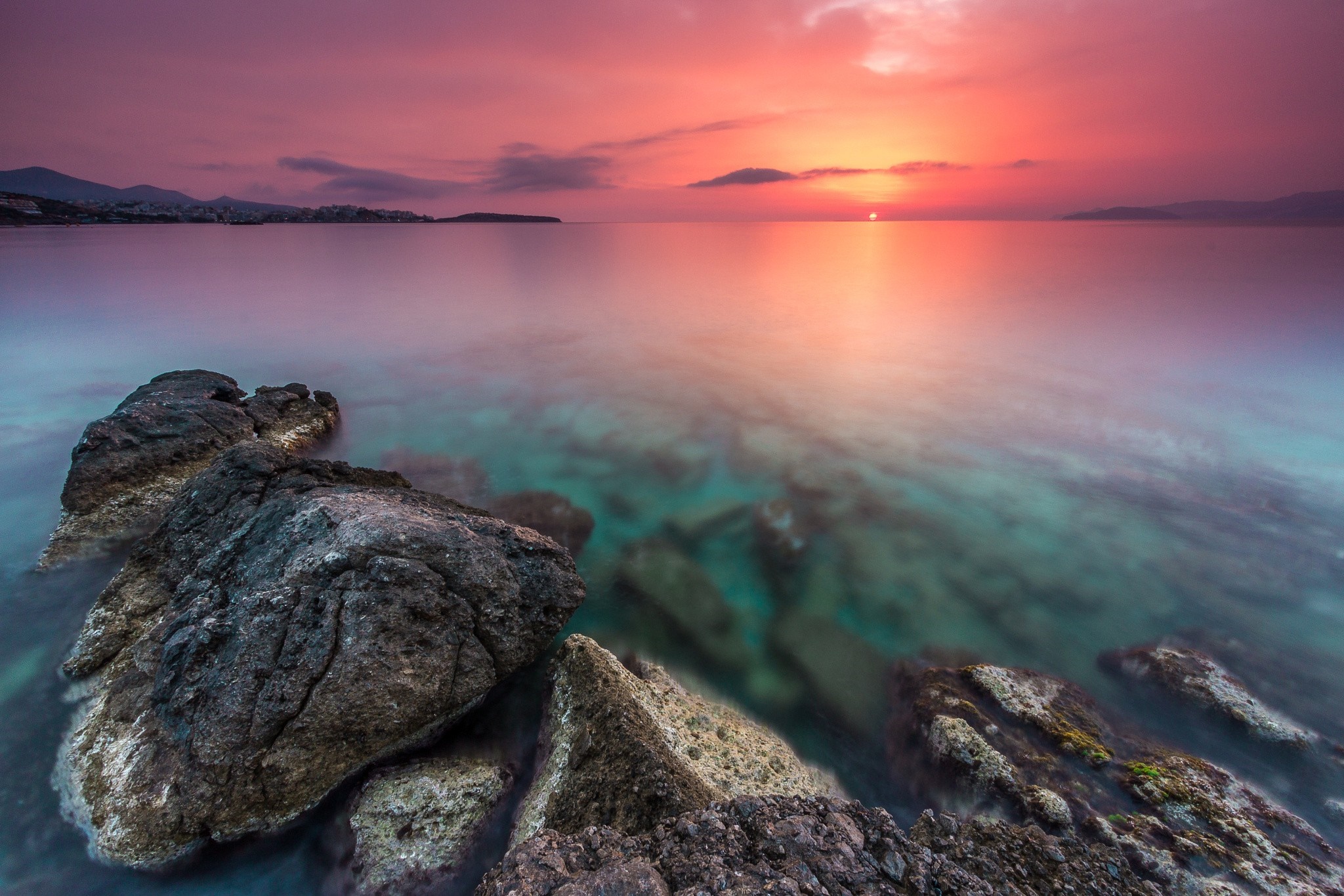 Sunset over the sea with rocks in the foreground HD Wallpaper