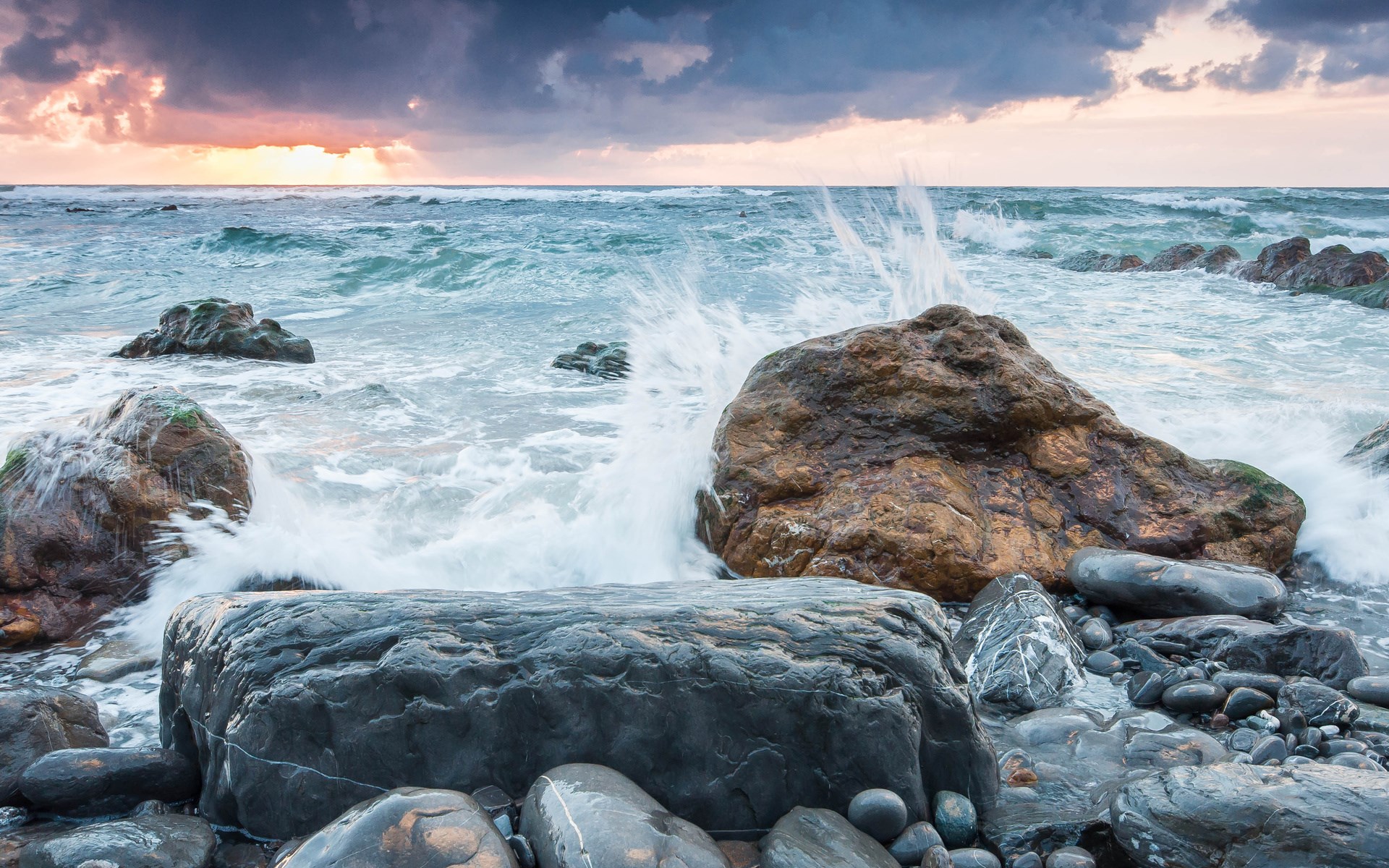 Waves crashing on rocky shore at sunset HD Wallpaper