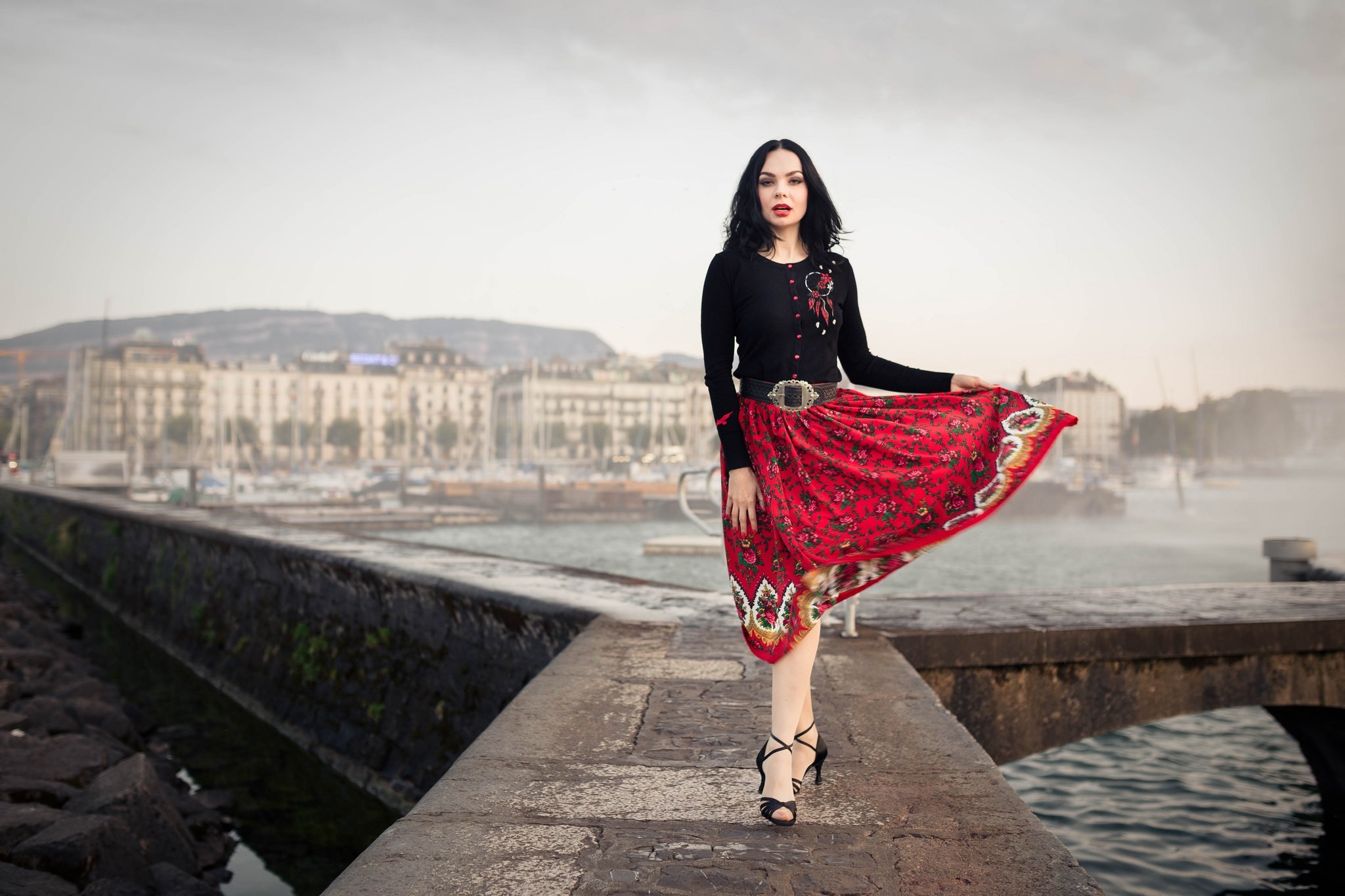 Woman in red skirt and black cardigan by the water HD Wallpaper